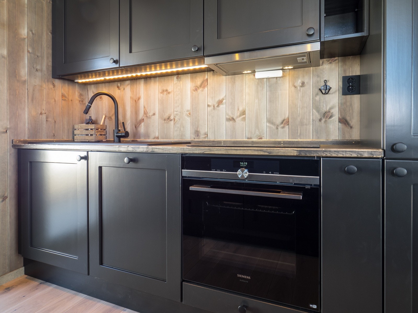 Heltre kjøkken i dempet sort med hvitevarer fra Siemens. Galleribilde