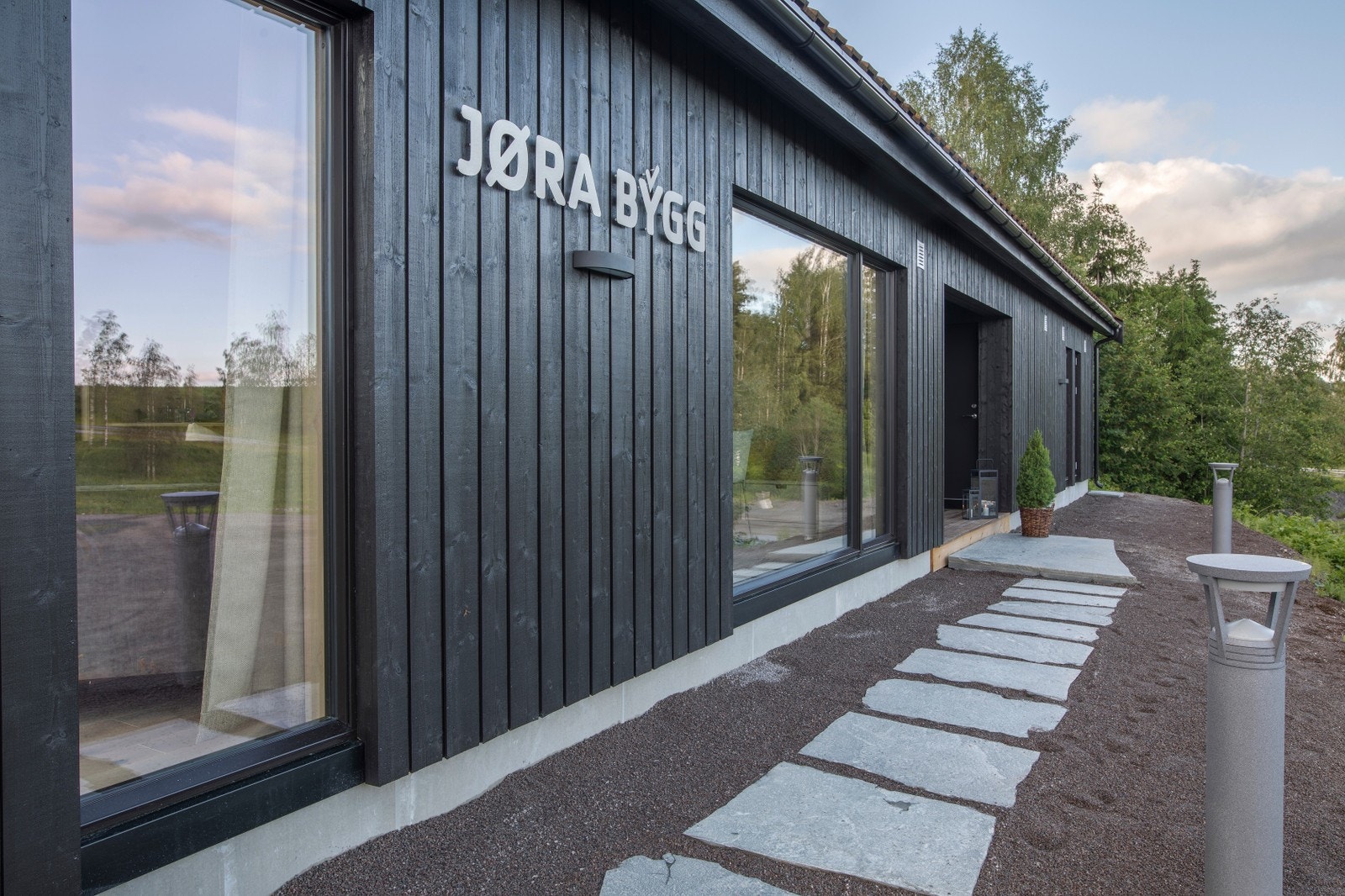 Flott fasade med tretak og inntrukket inngangsparti. Galleribilde