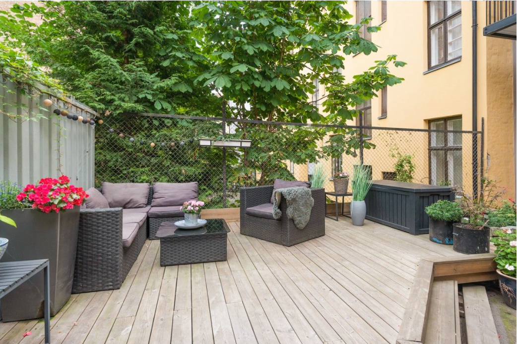 Felles platting med hyggelig sittegruppe og beplantning. Galleribilde