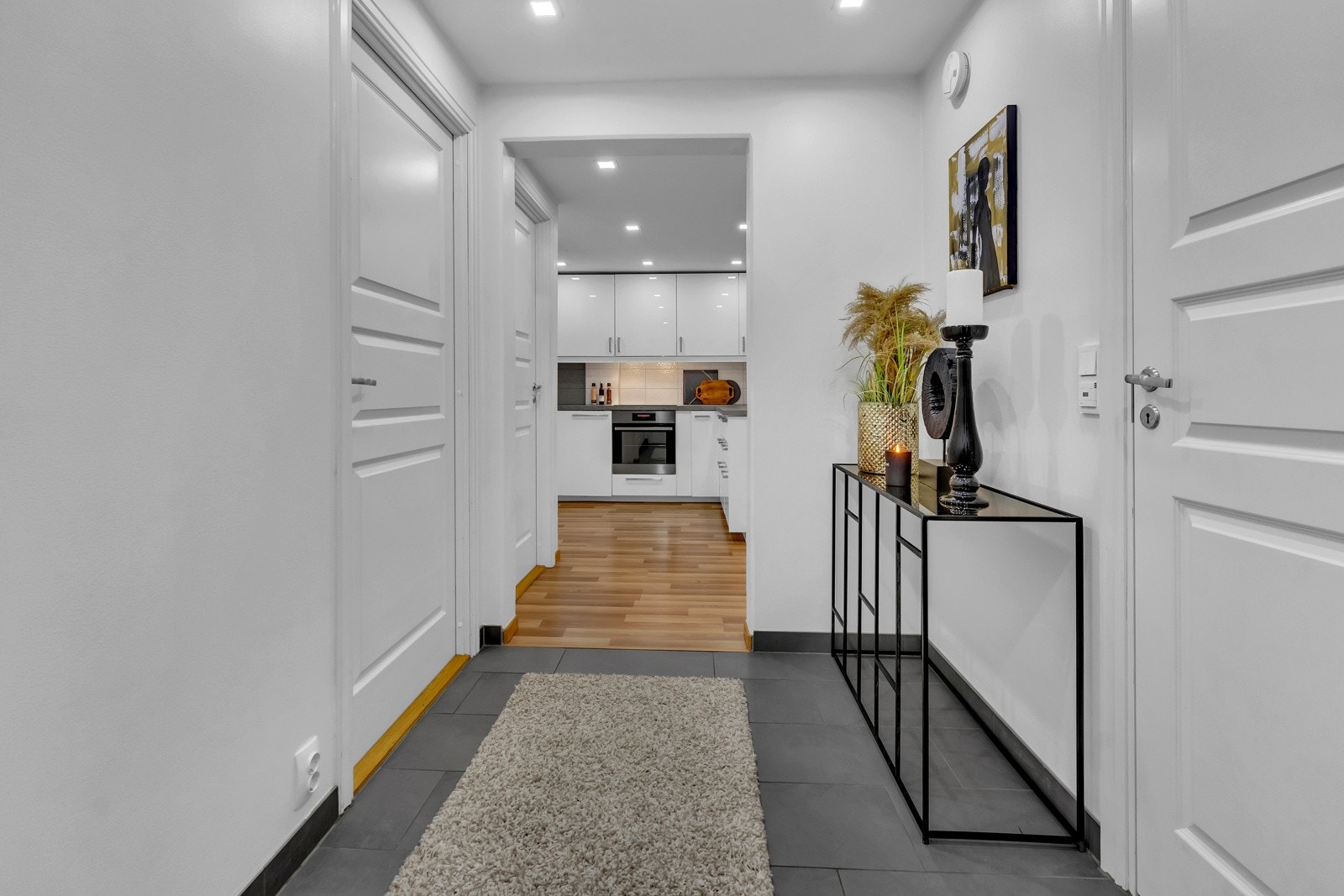 Rett ved ytterdøren er det montert callinganlegg og her er det også plass til en stumtjener. Litt lengre inn i entreen er det rom for et konsollbord eller lignende Galleribilde