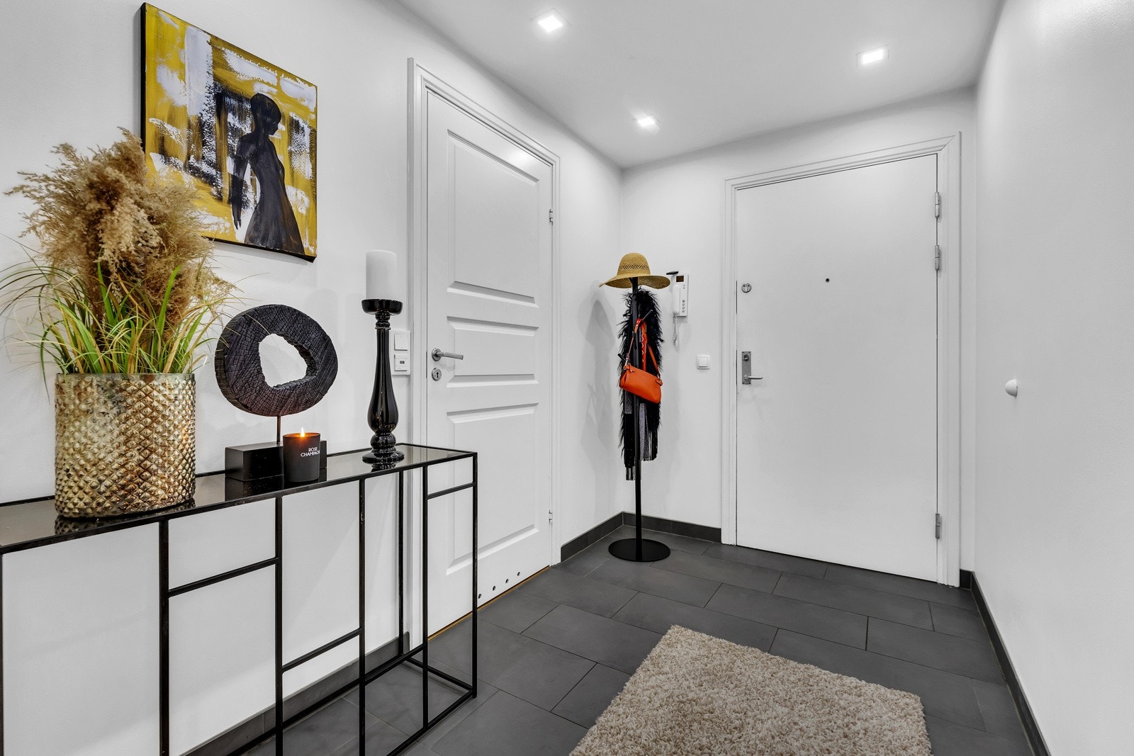 Vel inne får man et godt førsteinntrykk av oppgraderingen av leiligheten som ble utført i 2015. Her er det grå gulvfliser med sokkelflis og hvitmalte, glatte vegger Galleribilde