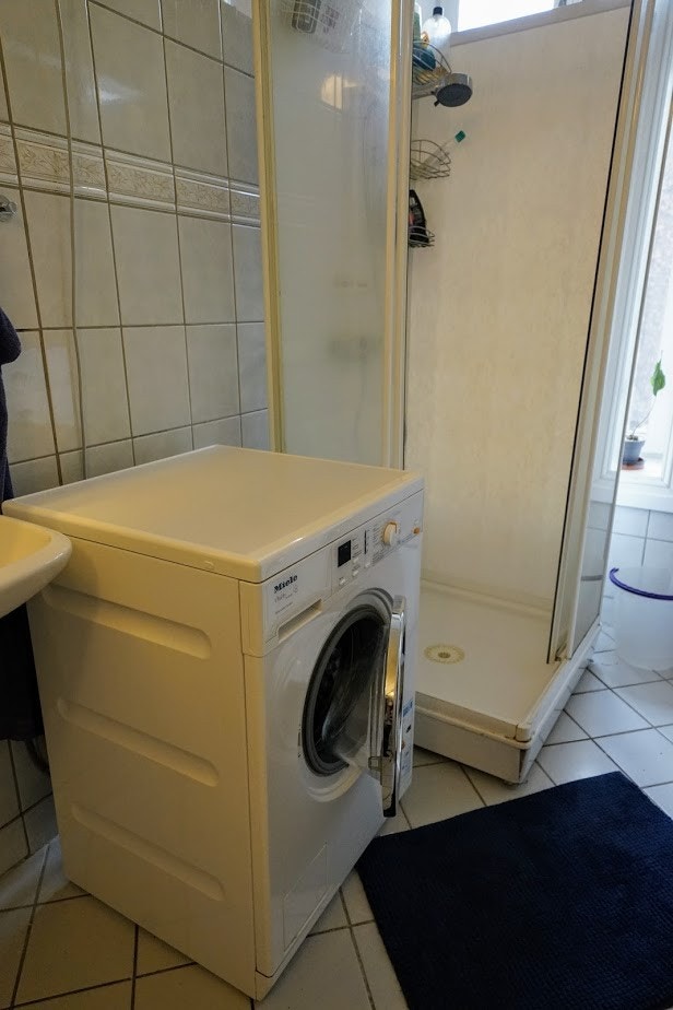Bade med Miele vaskemaskin og dusjkabinett og plass til å tørke klær Galleribilde