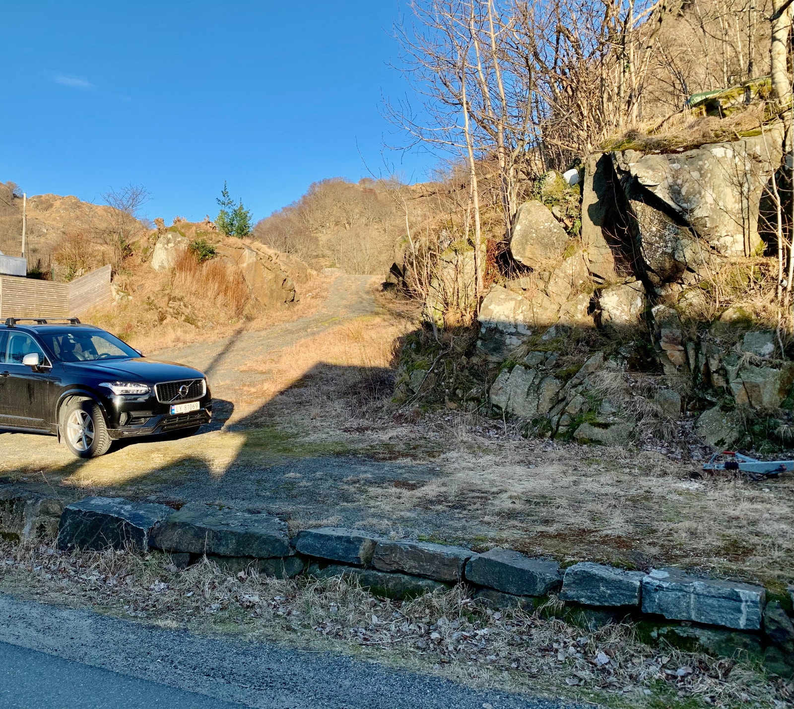 Steinmuren lags veien gir mulighet for parkering til biler. Galleribilde