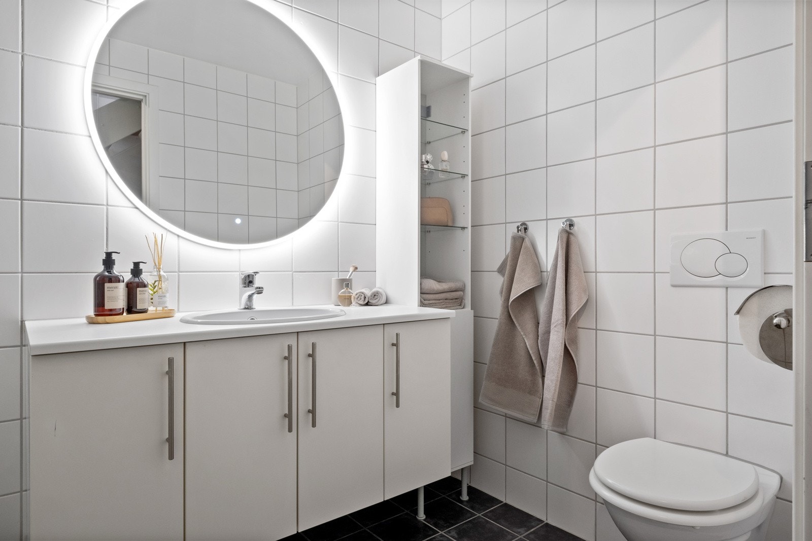 Pent og moderne baderom med fliser på gulv med behagelig gulvvarme og en pen tidløs innredning. Galleribilde