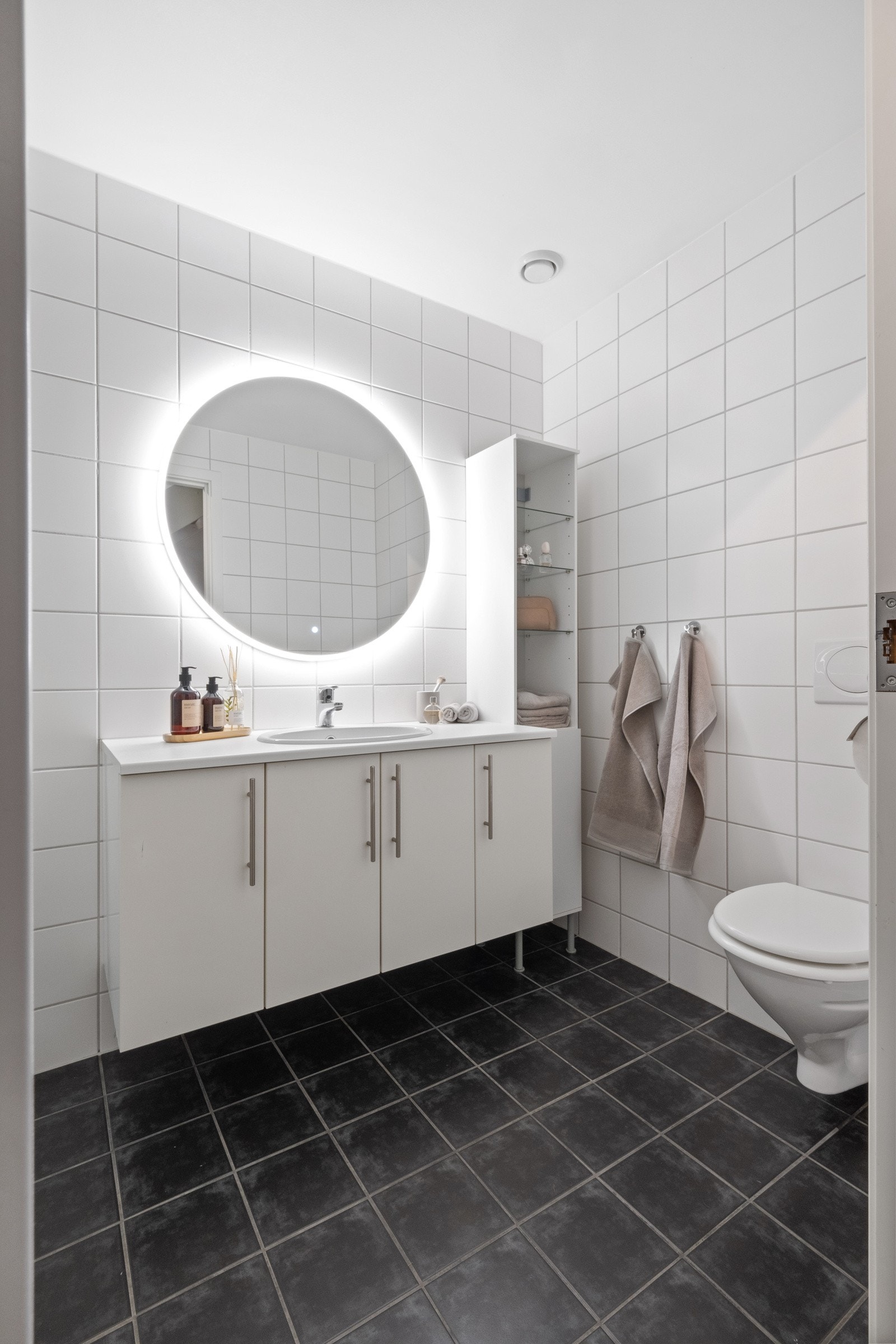 Videre er badet utstyrt med vegghengt toalett og et stort pent speil med innebygd belysning. Galleribilde