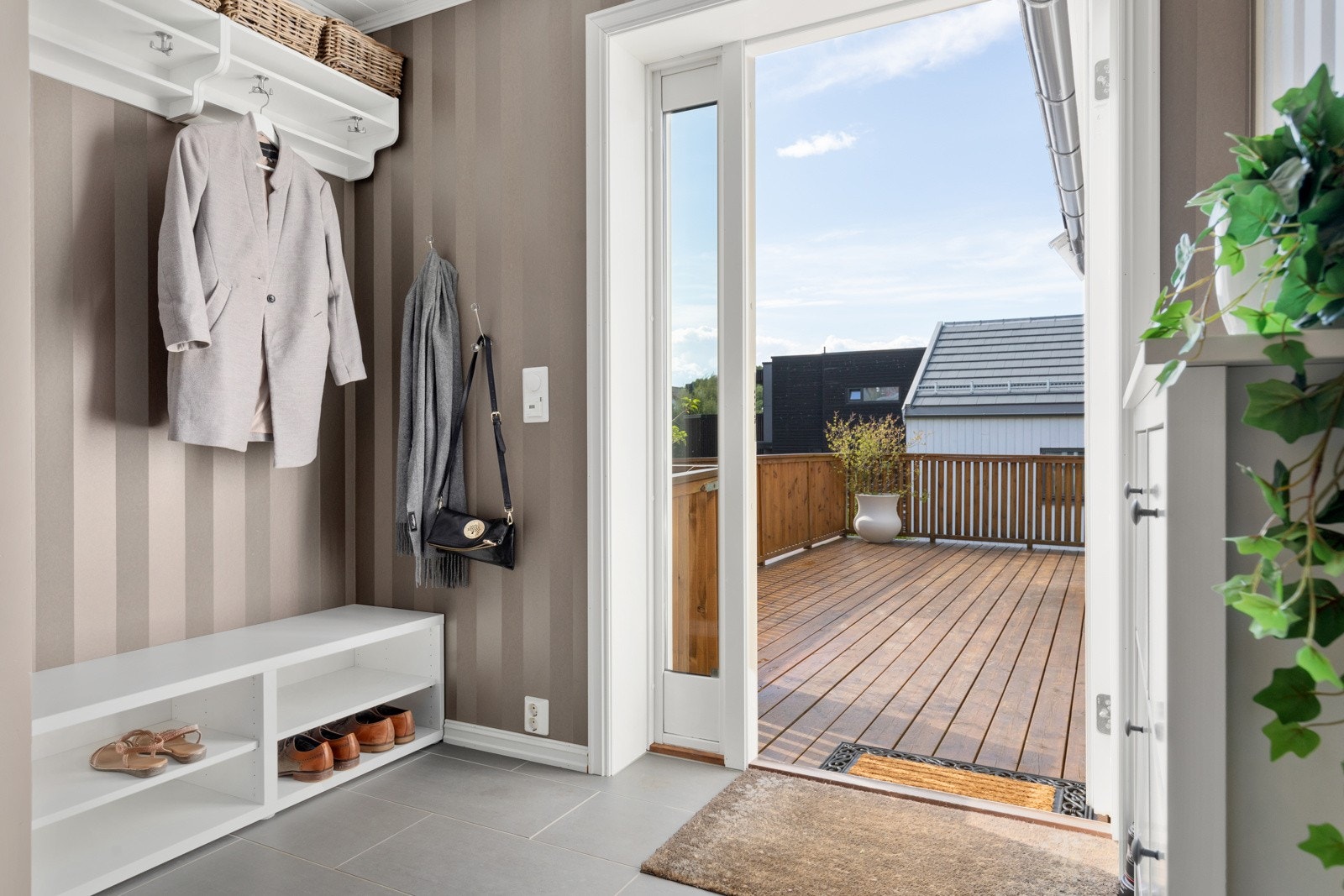 Når man kommer inn i boligen møtes man av en flott flislagt gang med plass til oppheng for jakker og skohyller. Her er det også behagelig varme i gulv. Galleribilde