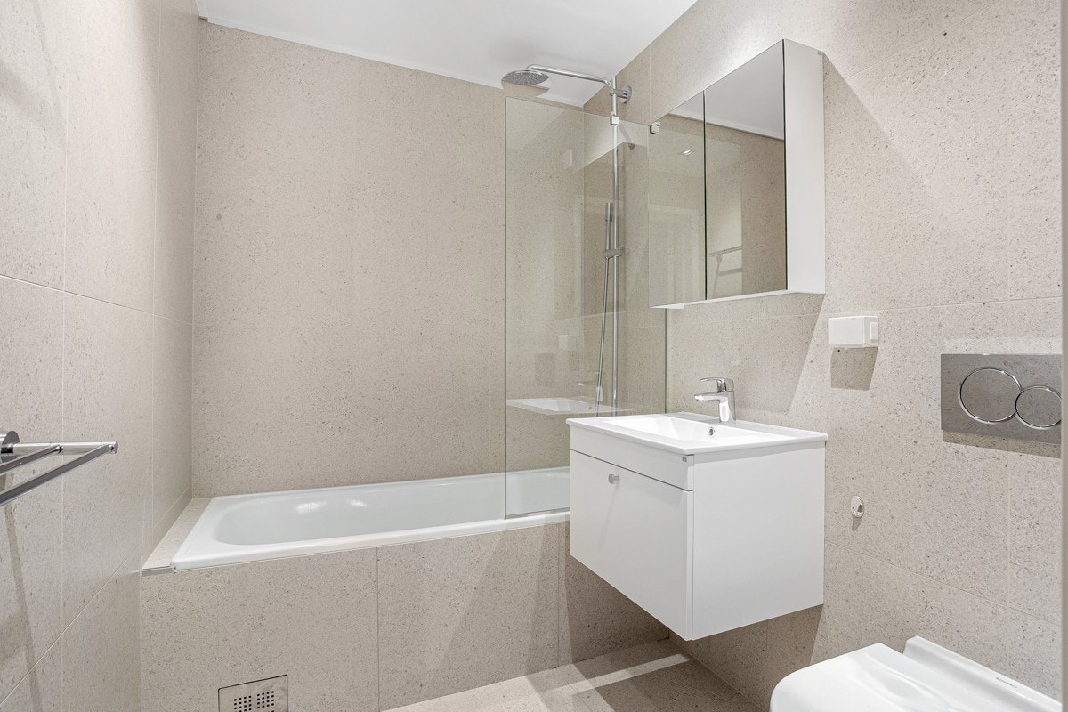 De to baderommene er plassert på hver sin side av trappen og er innredet i samme smakfulle stil. Galleribilde