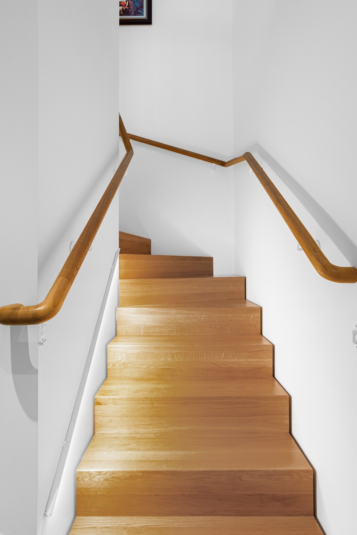 Trappen har gyldne inntrinn i lun kontrast til de hvitmalte veggene. Galleribilde