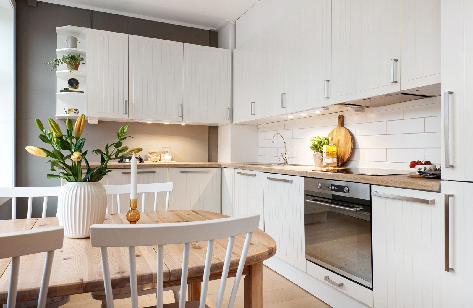 Kjøkkenet har hvite, profilerte fronter, stålhåndtak og heltre benkeplate. Galleribilde