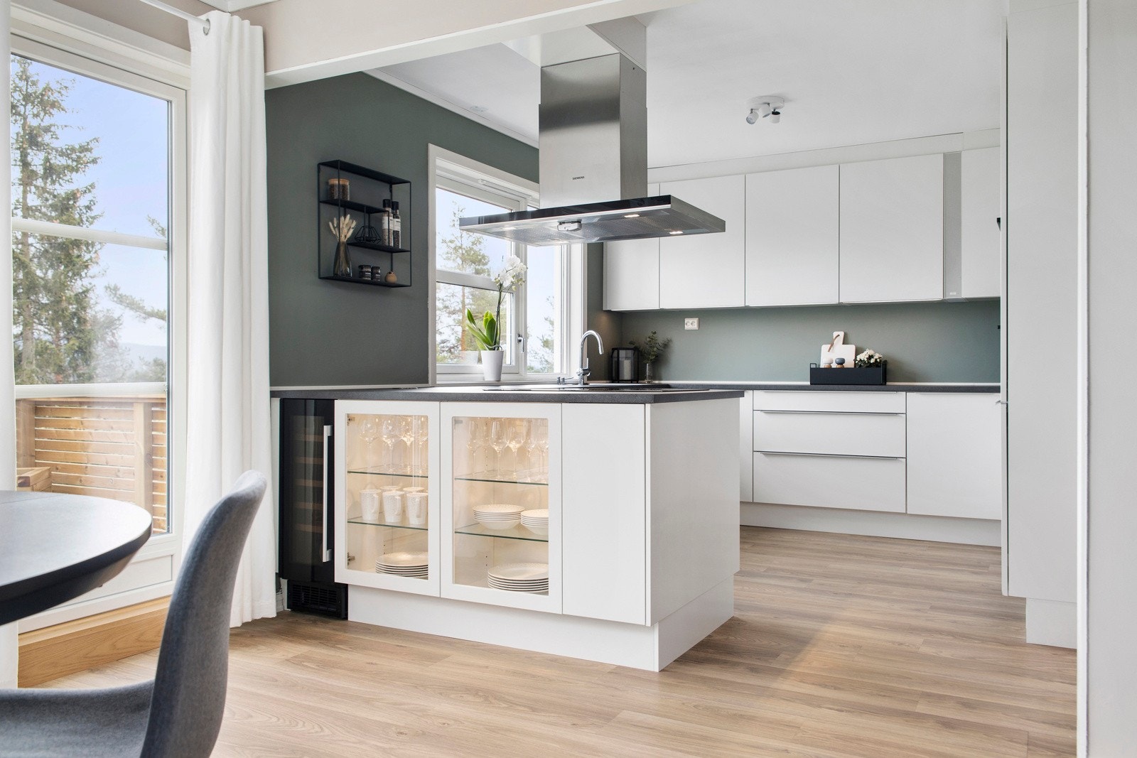 På fremsiden av kjøkkenet er det vitrineskap samt integrert vinskap ved siden av. Galleribilde