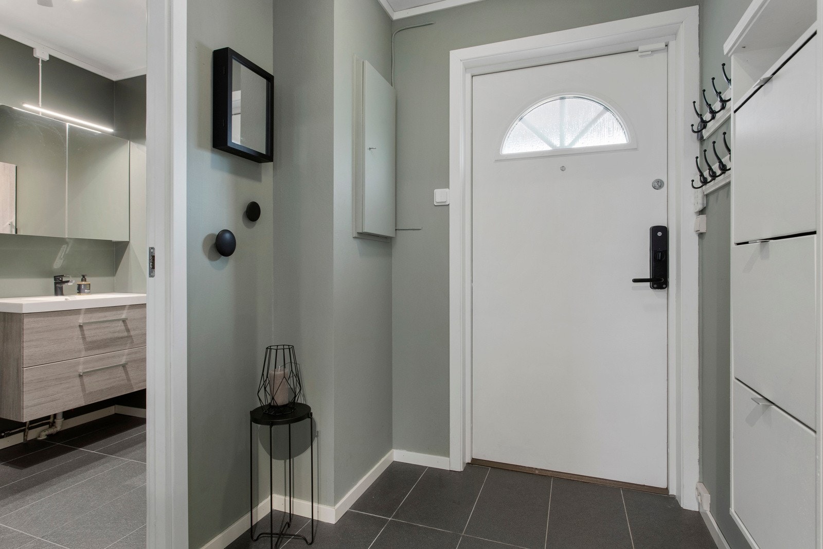 Innbydende entré med gulvfliser, slette vegger i grønt og plass til ytterbekledningen. Galleribilde