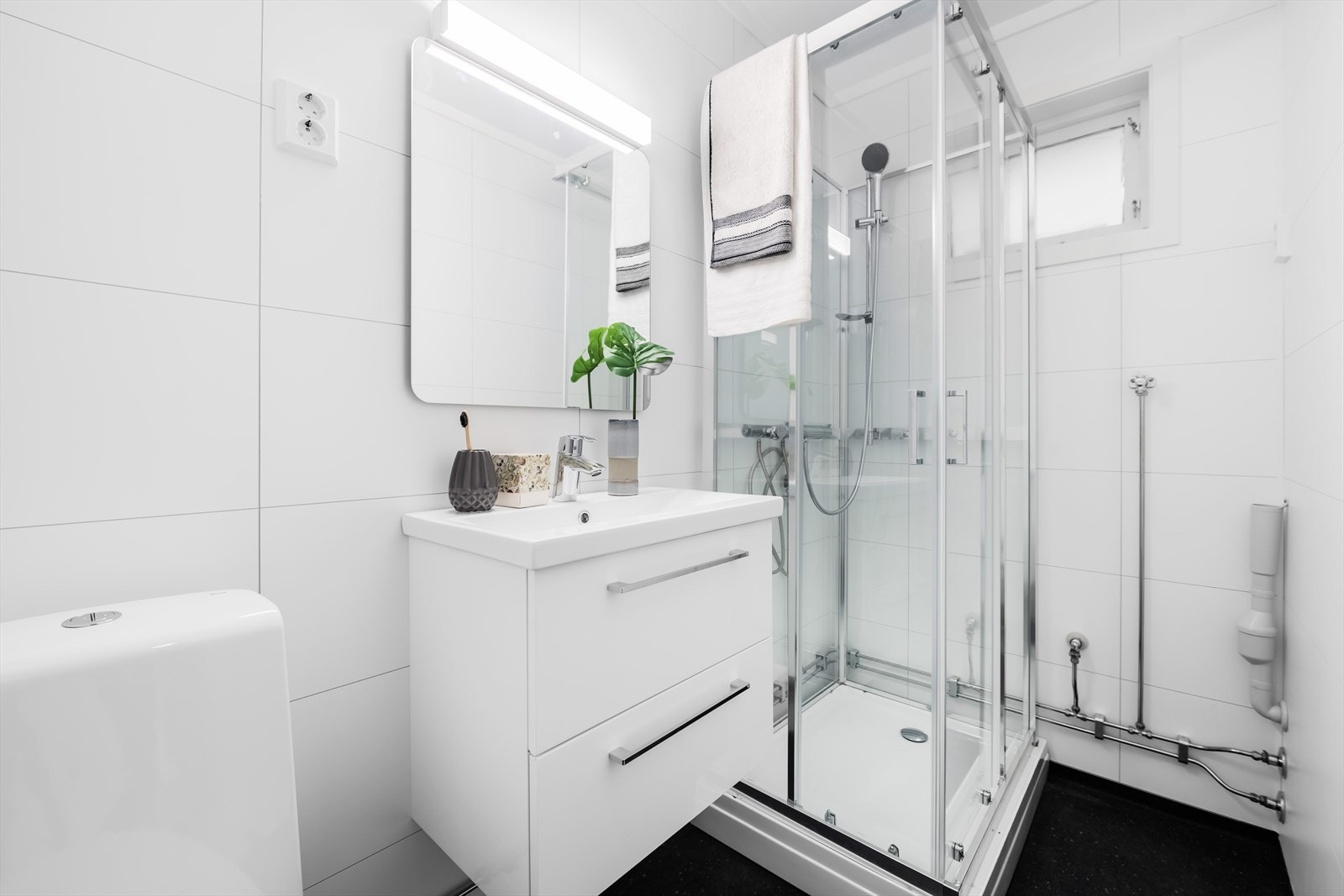 Nyoppusset baderom med sokkeltoalett, dusjkabinett og servantinnredning. Galleribilde