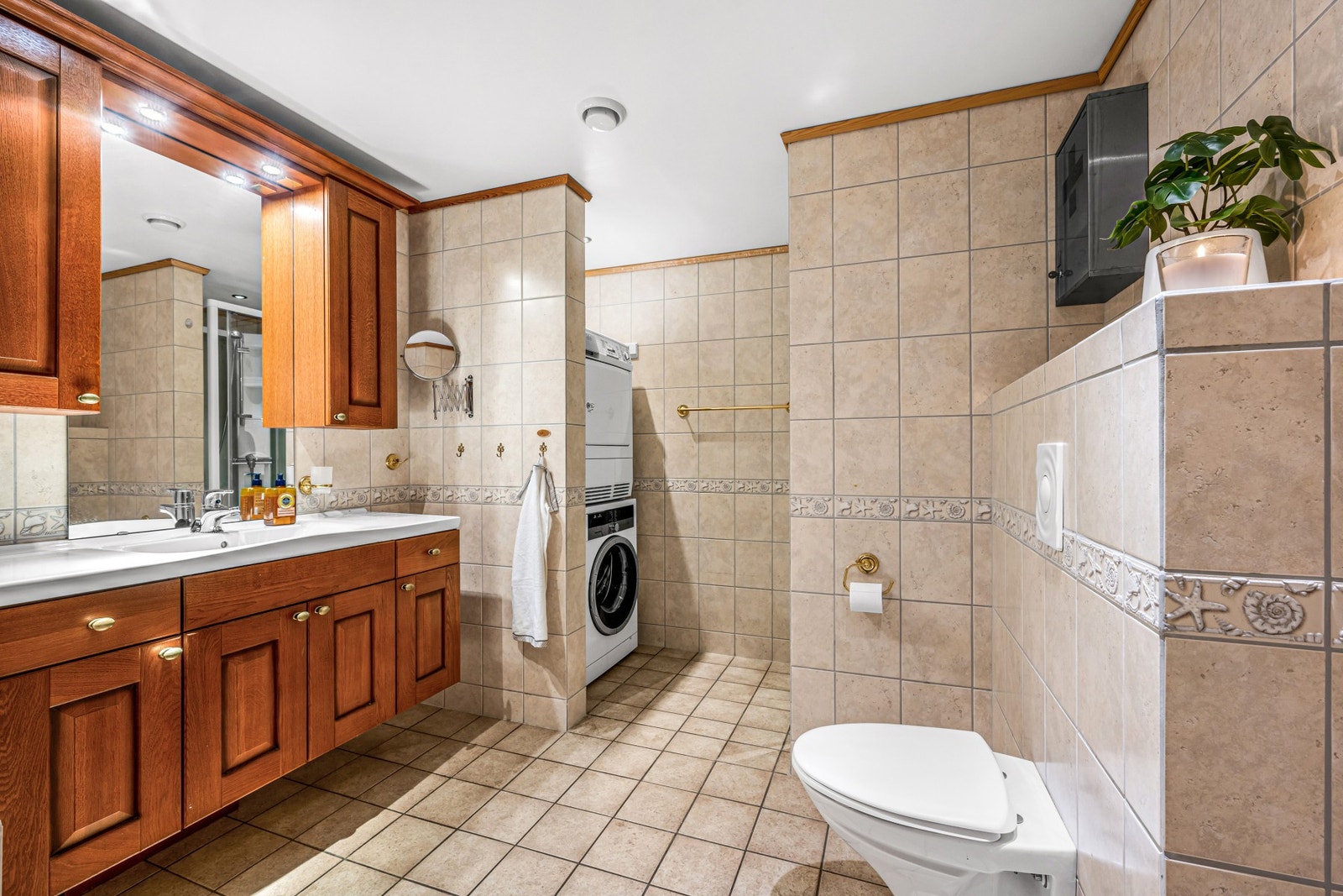 Flislagt og svært romslig bad - 10,2 kvm. Av utstyr på badet finnes dusjkabinett fra 2014, vegghengt toalett, opplegg for vaskemaskin, boblebadekar og vask. Galleribilde