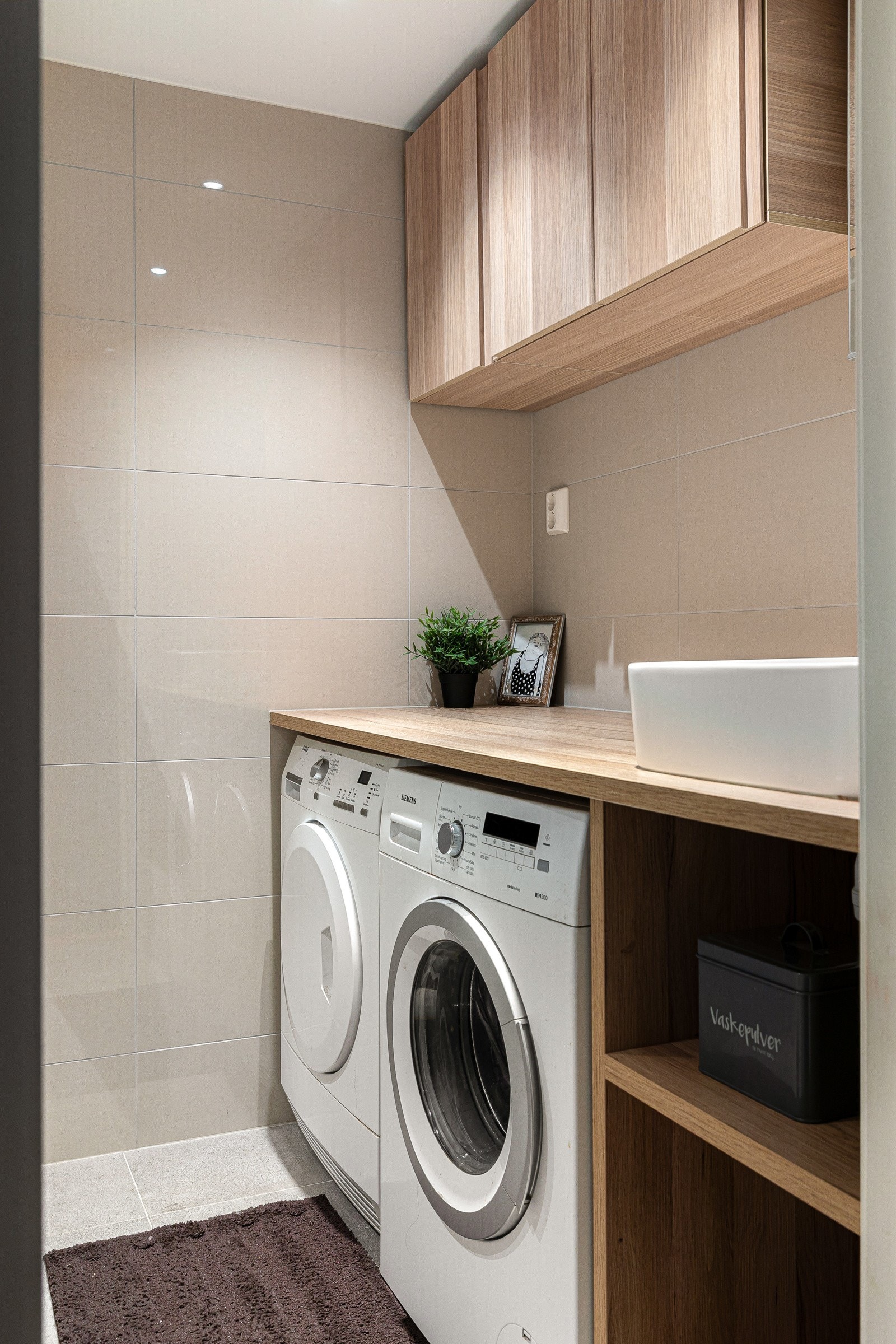 Bad 2. Badet har dusjhjørne med glassdører, servantskap, vegghengt toalett og oppplegg for vaskemaskin og tørketrommel. Galleribilde