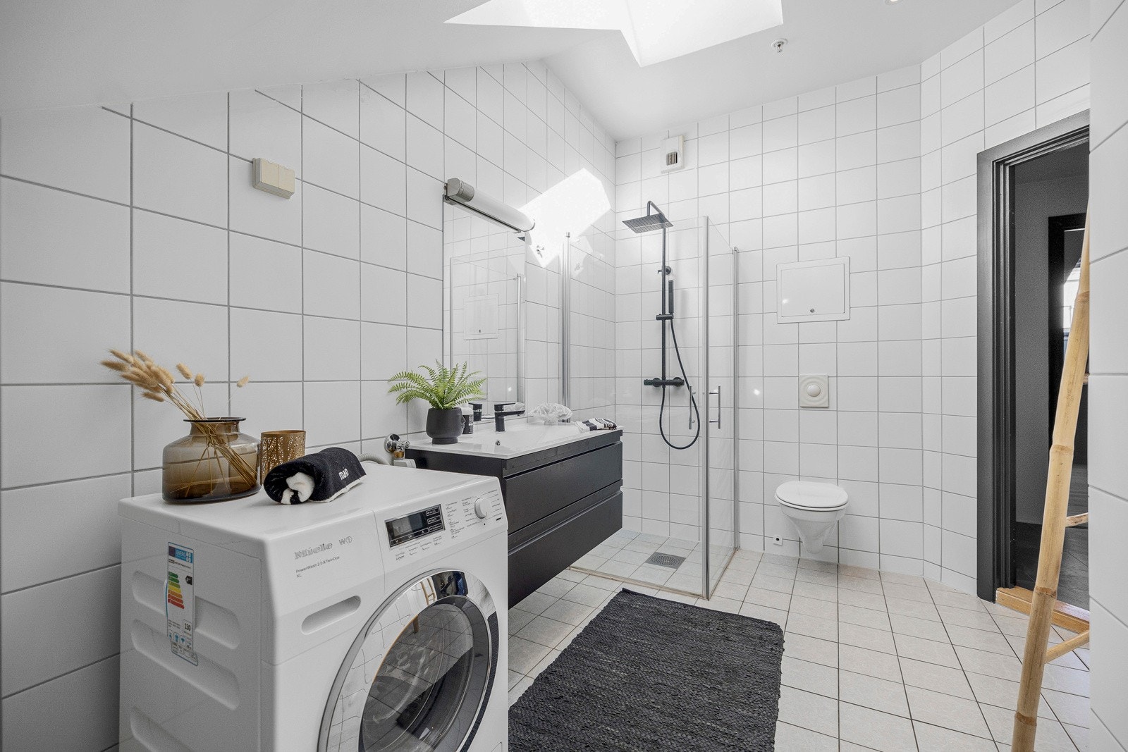 Badet har lyse fliser på gulv og vegger, samt downlights og gulvvarme. Galleribilde