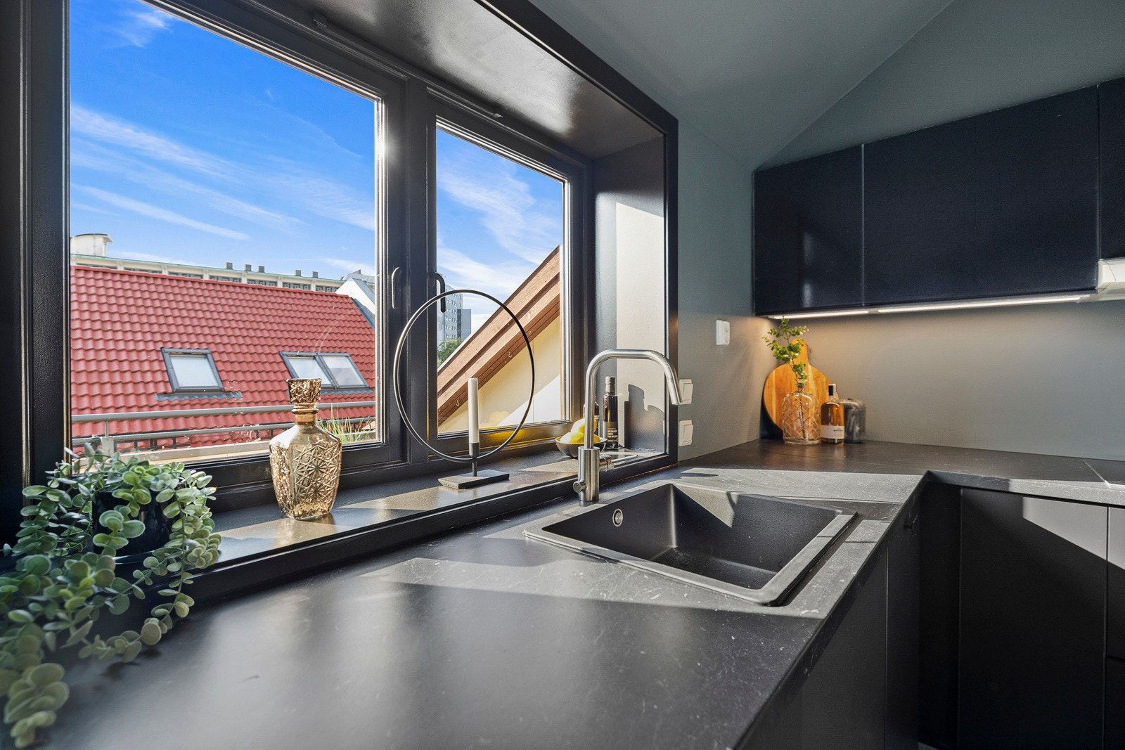 Vindu over kjøkkenbenken gir en lys, hyggelig arbeidsplass. Galleribilde