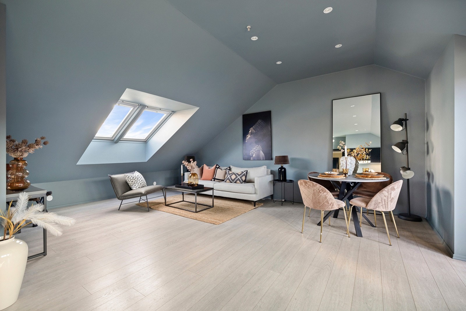 Stuen har lyst laminatgulv, overflater malt i en moderne fargetone og downlights i himling. Galleribilde