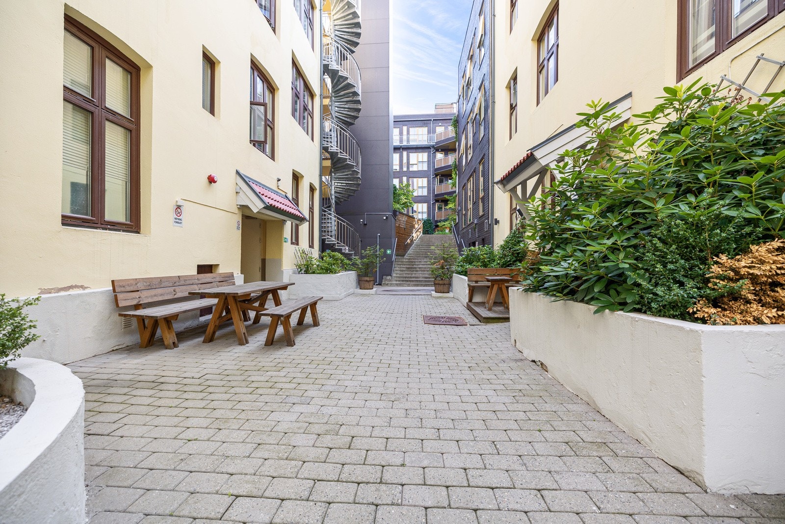 Mellom byggene ligger steinlagt gårdsrom med trapp til indre bakgård. Galleribilde