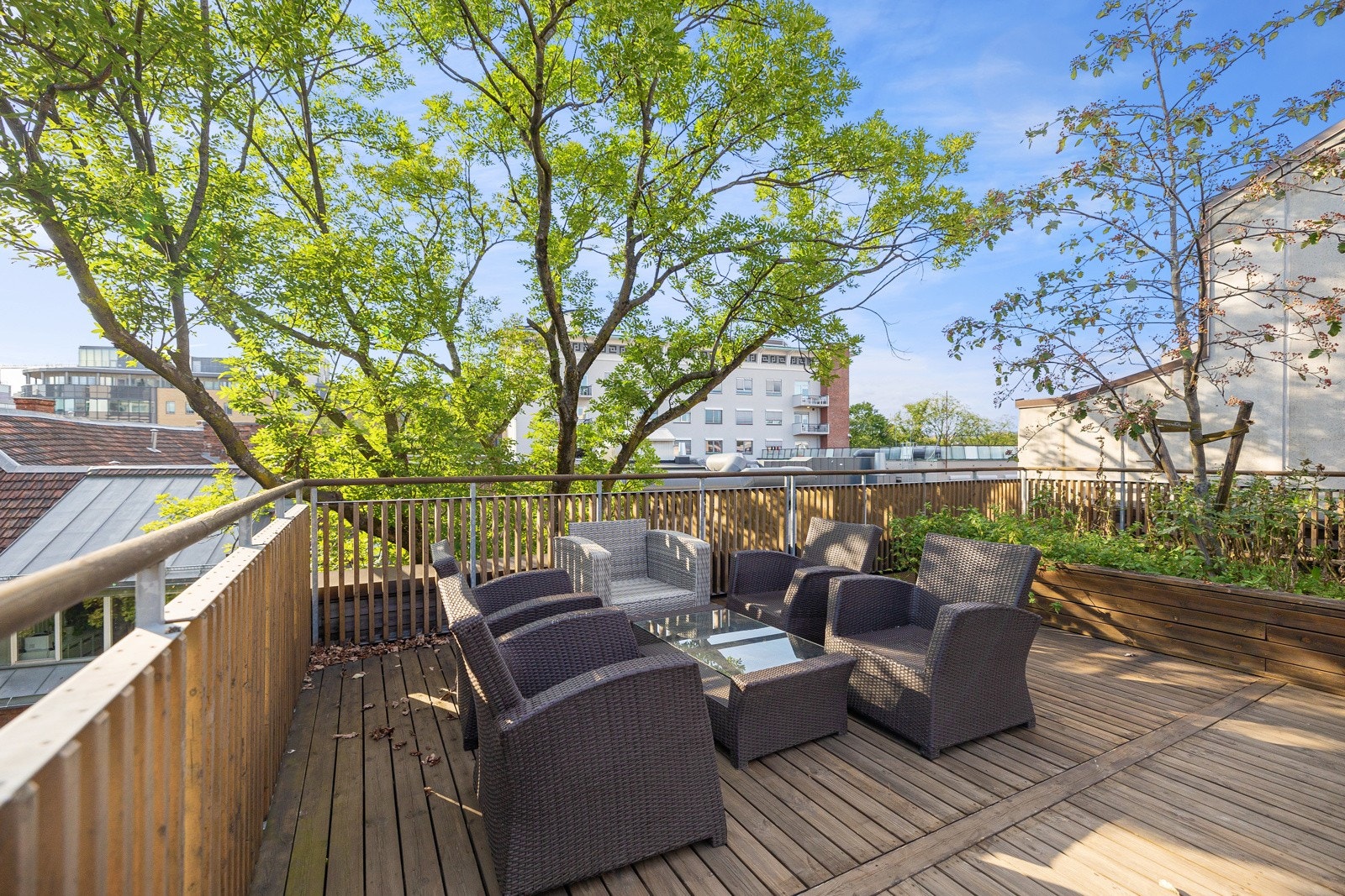 Takterrassene har pent dekke, spilerekkverk og beplanting i kasser. Galleribilde