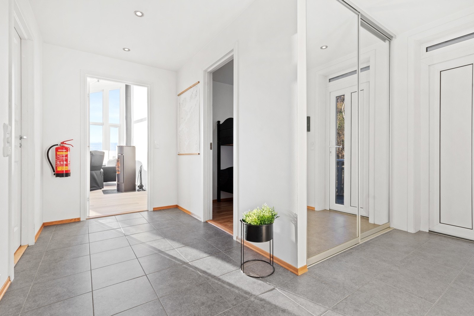 Velkommen inn. Hytta har to innganger. Den ene via kjøkkenet og den andre på baksiden av hytta. Her er det flislagte gulvfalter og god plass til sko og klesavheng i skyvedørsgarderoben. Gangen fordeler til WC, bad, bod og to soveorm. Galleribilde