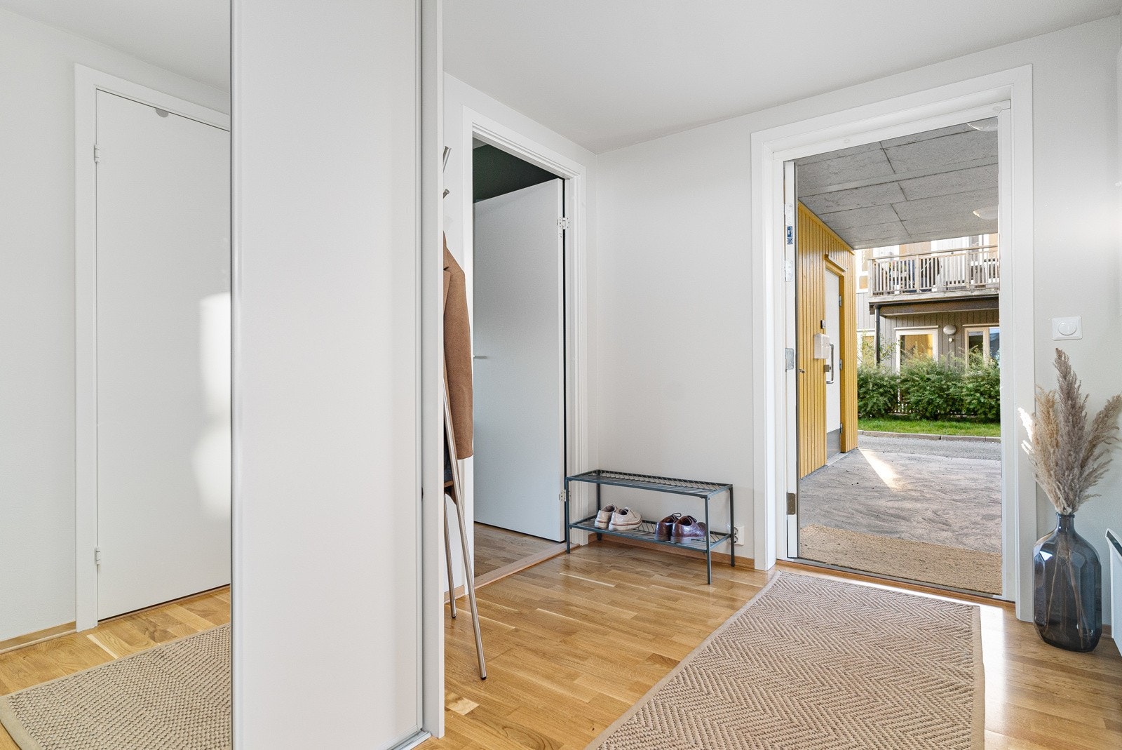 Det første som møter deg i leiligheten er et innbydende inngangsparti med god plass til oppheng av yttertøy og sko, skjermet fra stue og kjøkken Galleribilde