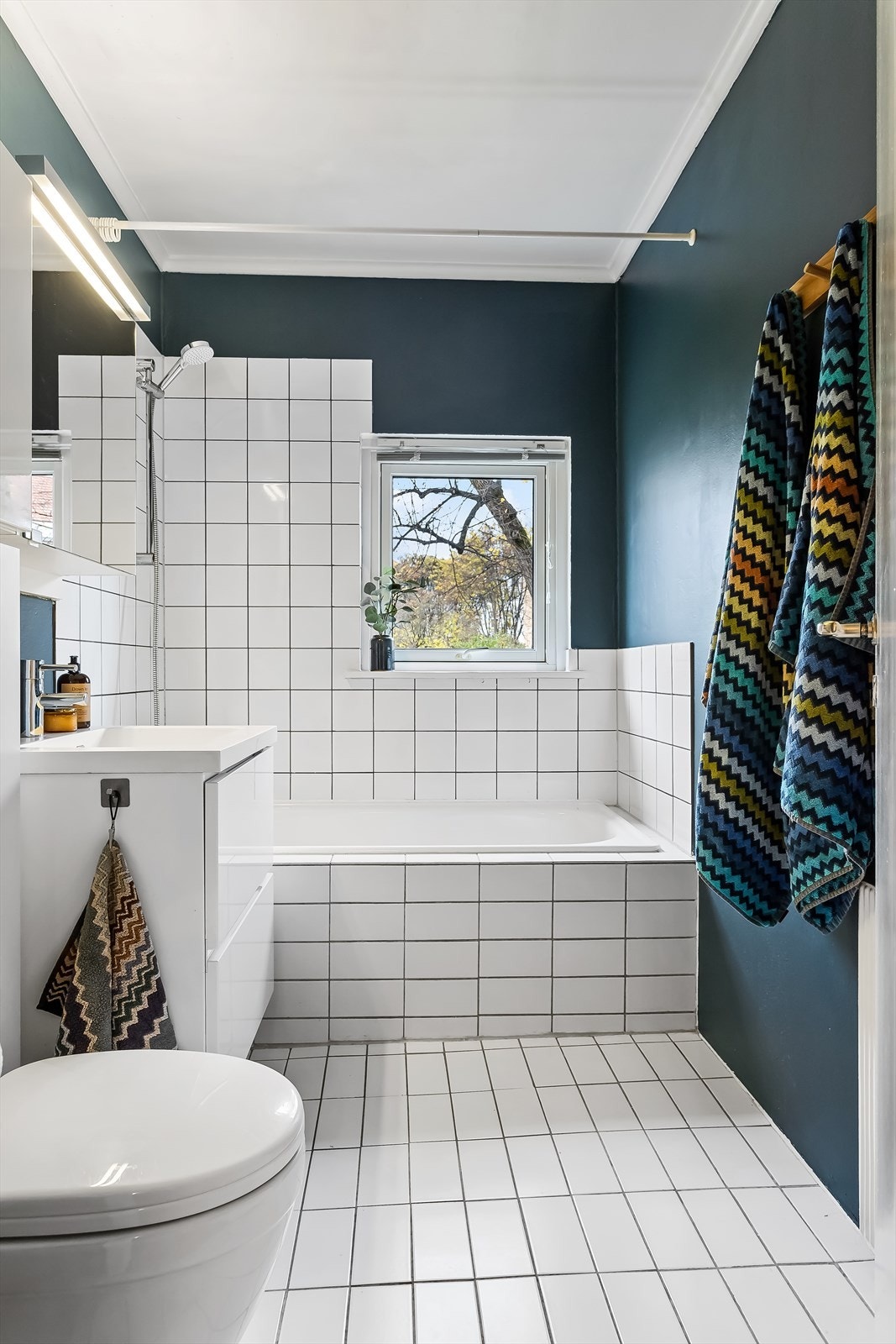 Flislagt bad med praktisk badekar. Vindu sikrer naturlig lysinnslipp. Galleribilde