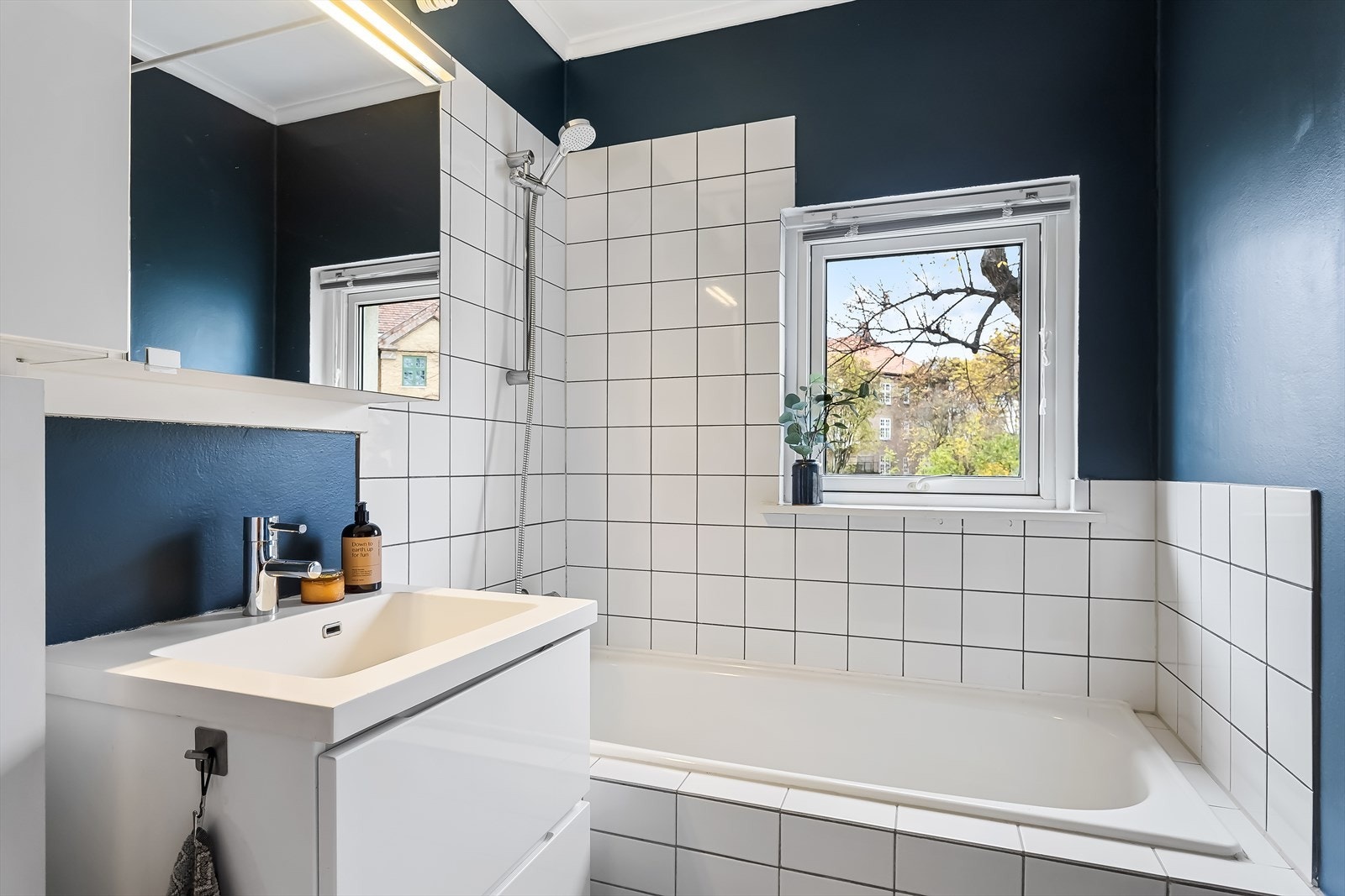 Bad innredet med badekar og hvit servant. Varmekabler i gulv. Galleribilde