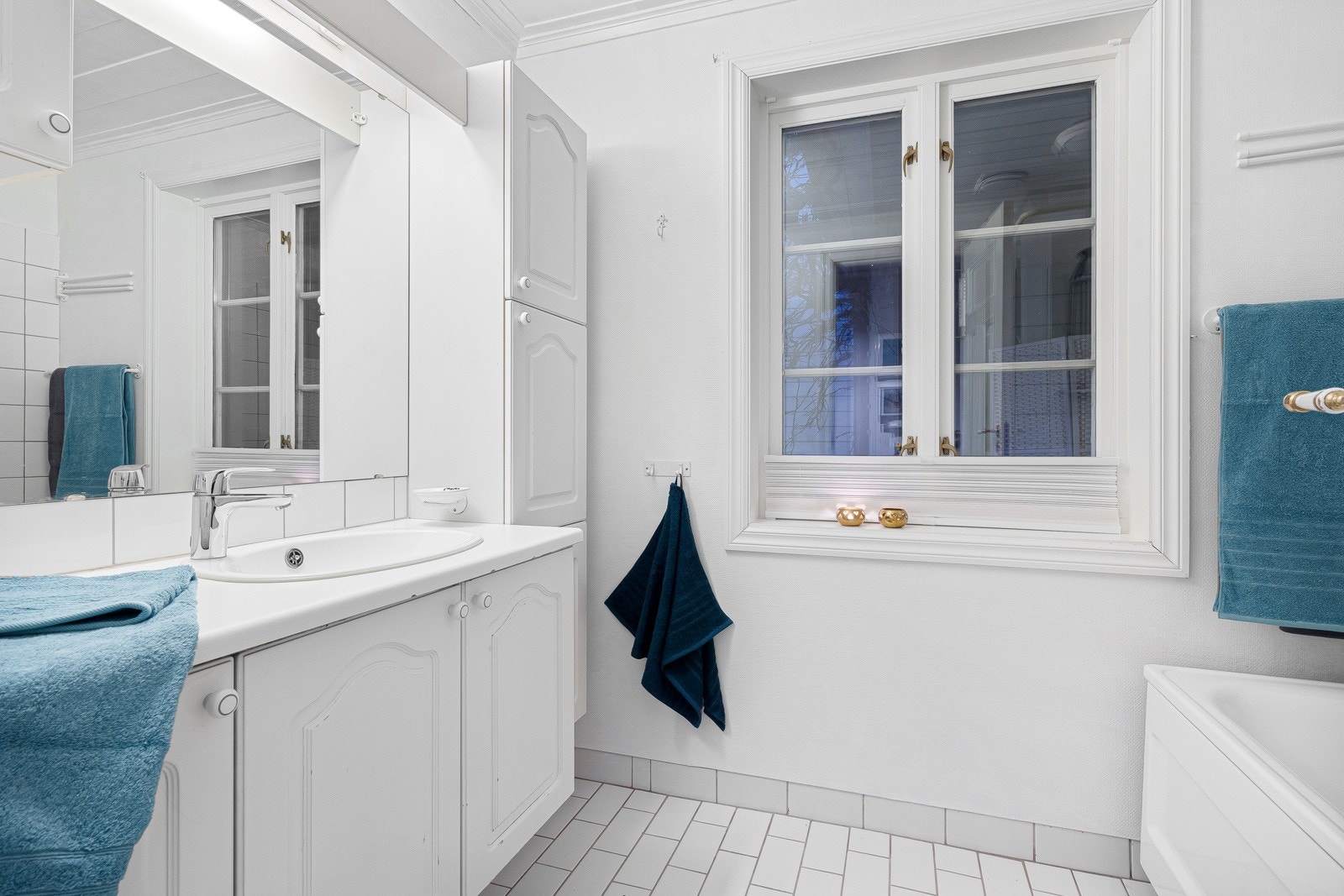 Baderommet er på 4 m² med flislagt gulv. Badet er utstyrt med varmekabler i gulv og badekar Galleribilde