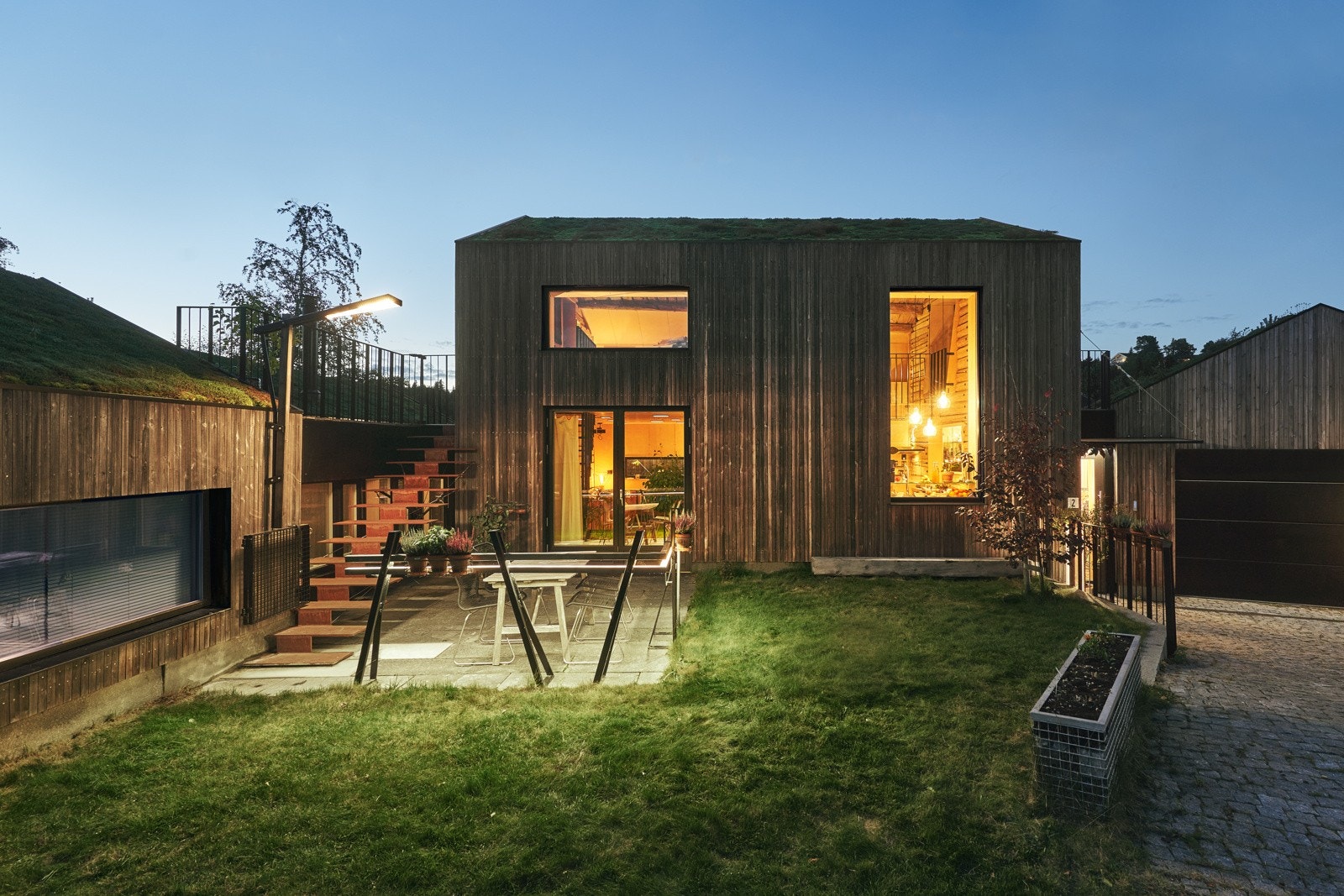 Trappen fra takterrassen leder ned til formiddagsplassen. Her er det direkte utgang fra stue. Underlaget er av 40mm tykke skiferplater. Galleribilde