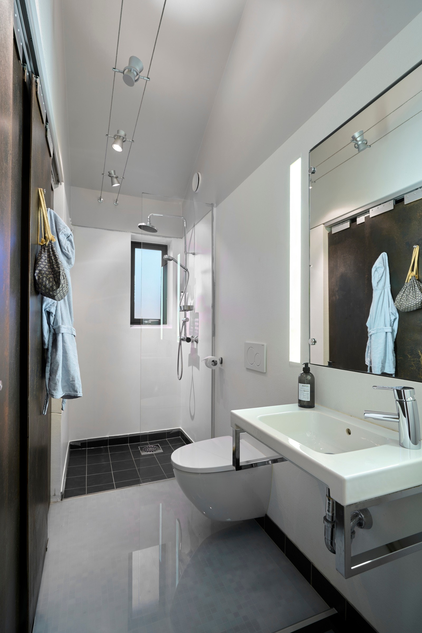 Praktisk bad på 4 kvm med elegante løsninger. Teknisk rom er å finne bak de rustrøde skyvedørene og er på 2 kvm. Galleribilde