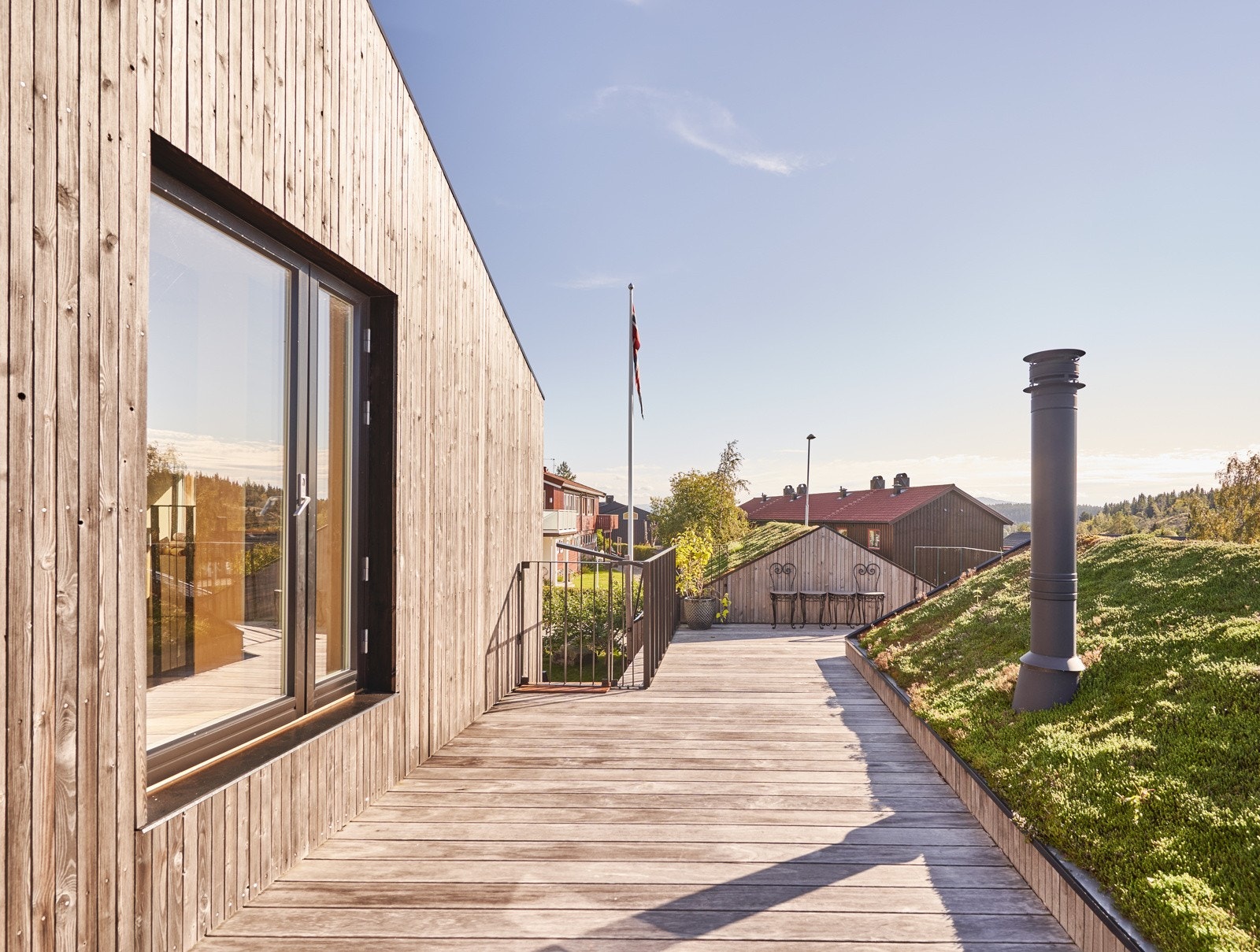 Boligen byr på en stor takterrasse som her vender mot sør og har direkte utgang fra hemsen. Det går en trapp ned til plena utenfor stua. Selger sier at sola treffer ca. 11:00-23:00 midt på sommeren. Galleribilde