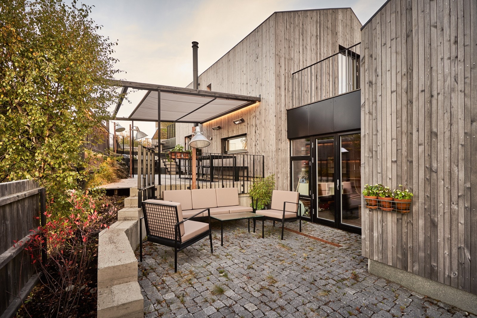 Boligen nyter også en ettermiddagsplass med direkte utgang fra mellomstuen. Her kommer kveldssola, og plassen er flott belagt med brostein. Galleribilde