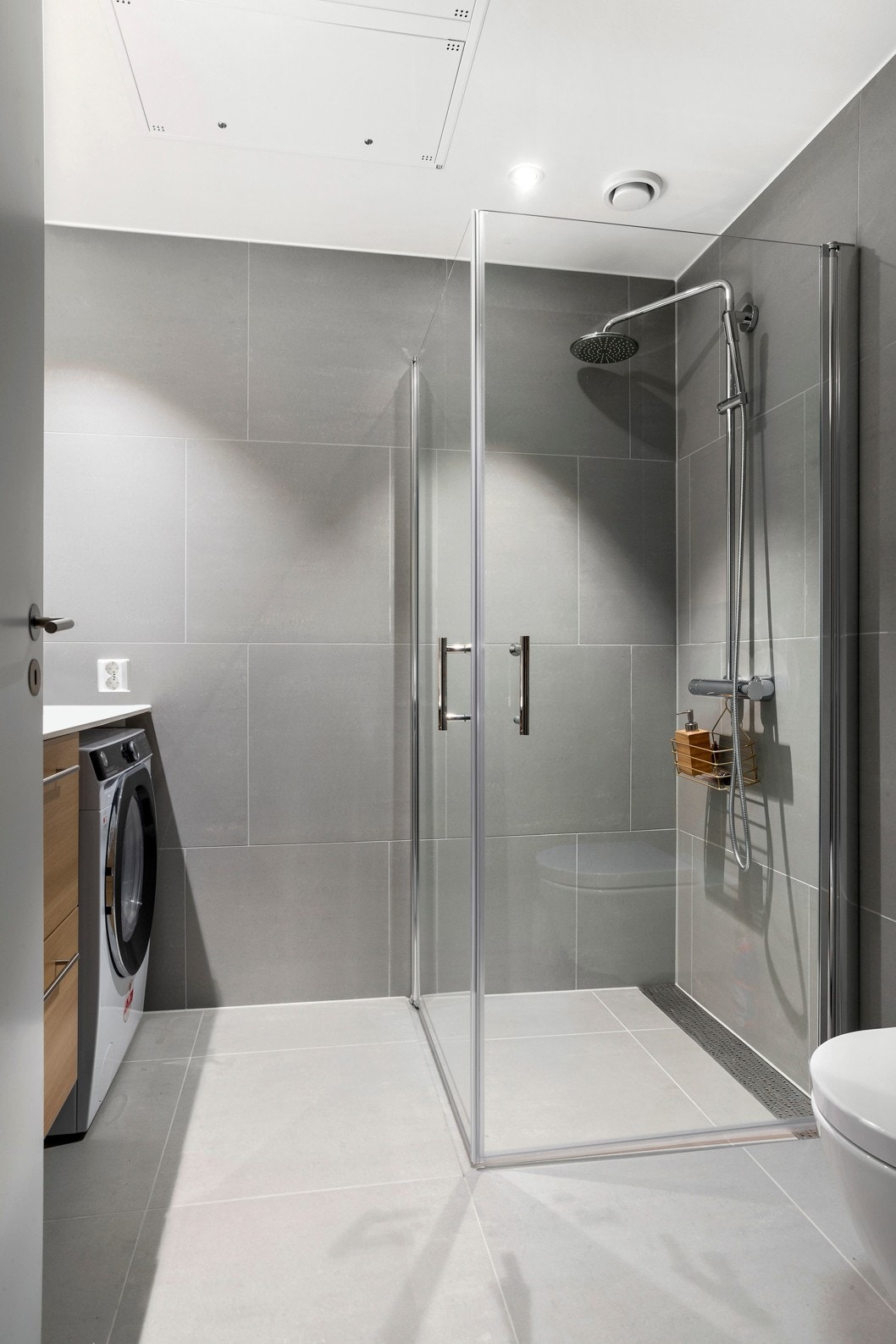 Badet er belagt store fliser og innlagt varmekabler. Belysning: Spotlights med dimmer Dusjen er av typen "Rainfall" med stort hode og loddrett fall. Galleribilde