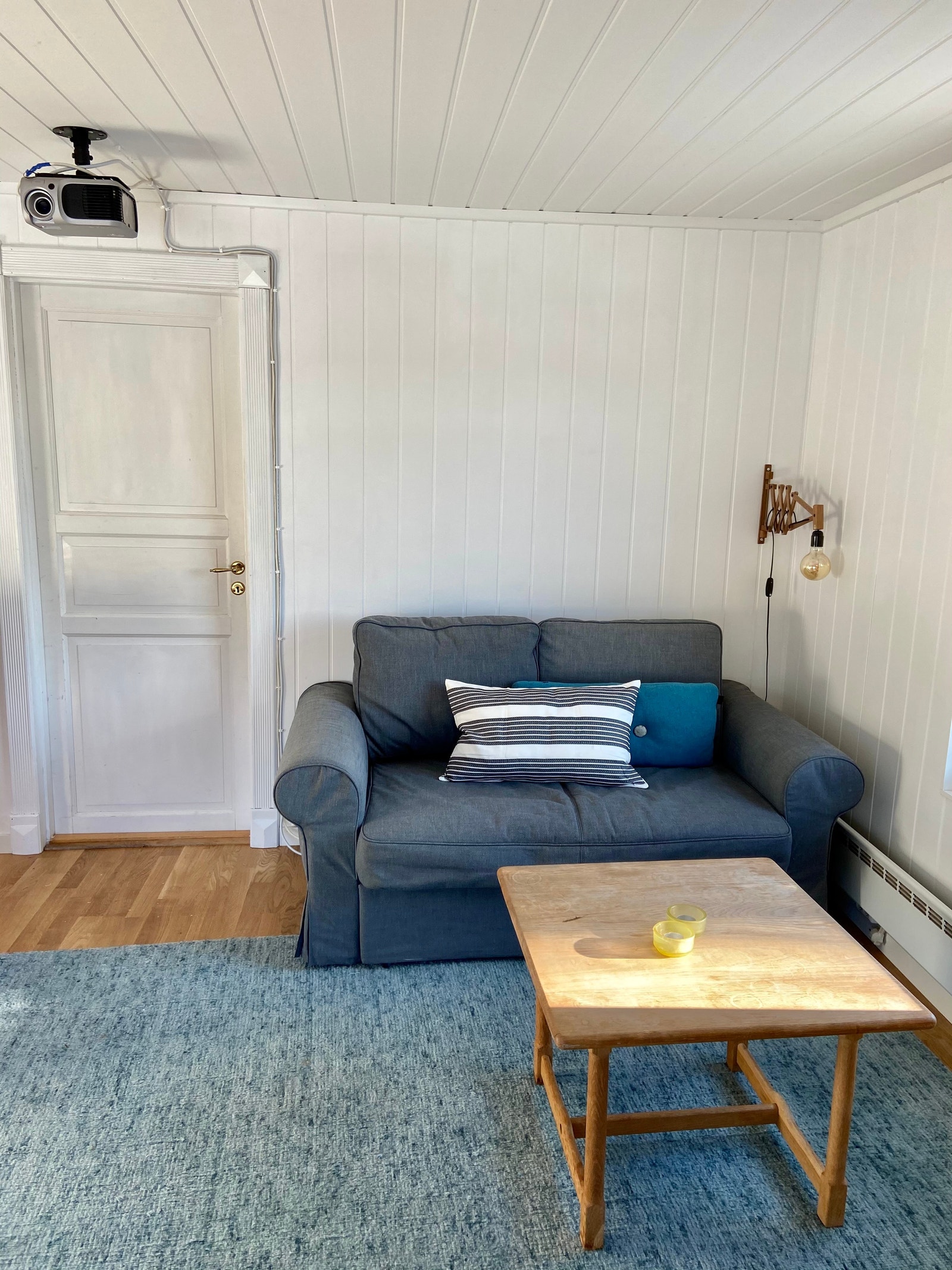 Stue i underetasjen med sovesofa, prosjektor i taket og store vinduer Galleribilde