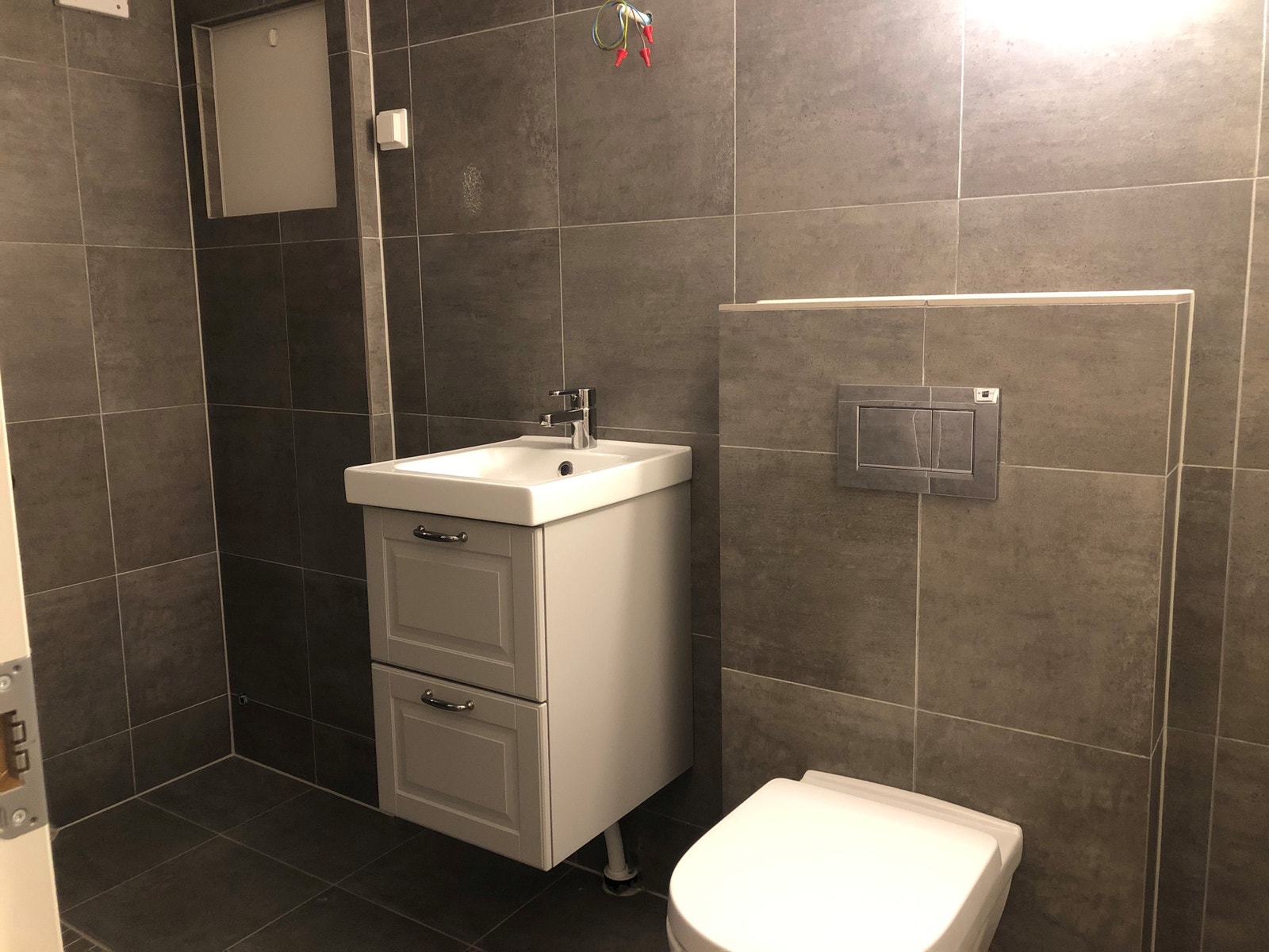 Flislagt bad med varmekabler. Speilskap med lys installert Galleribilde