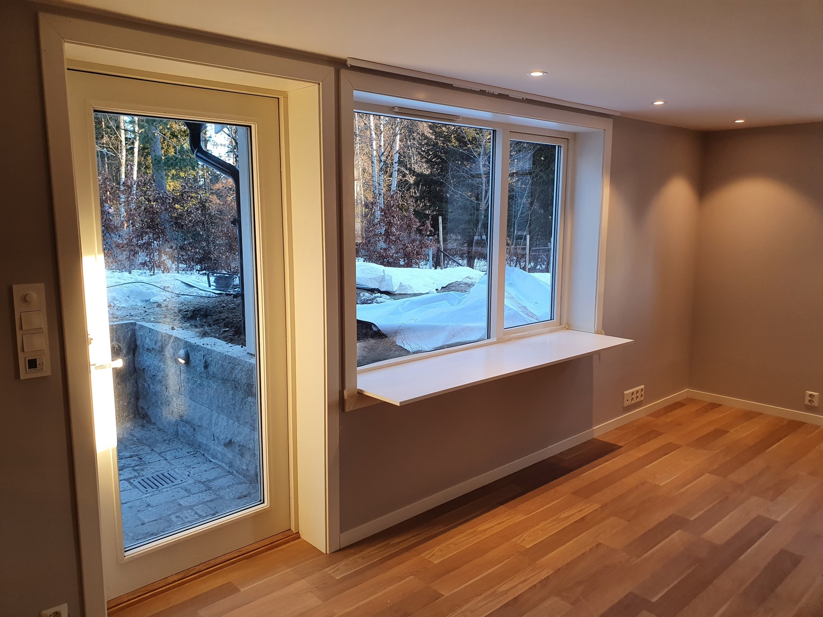 Inngangsdør og vindusbord med utsikt til skogen Galleribilde