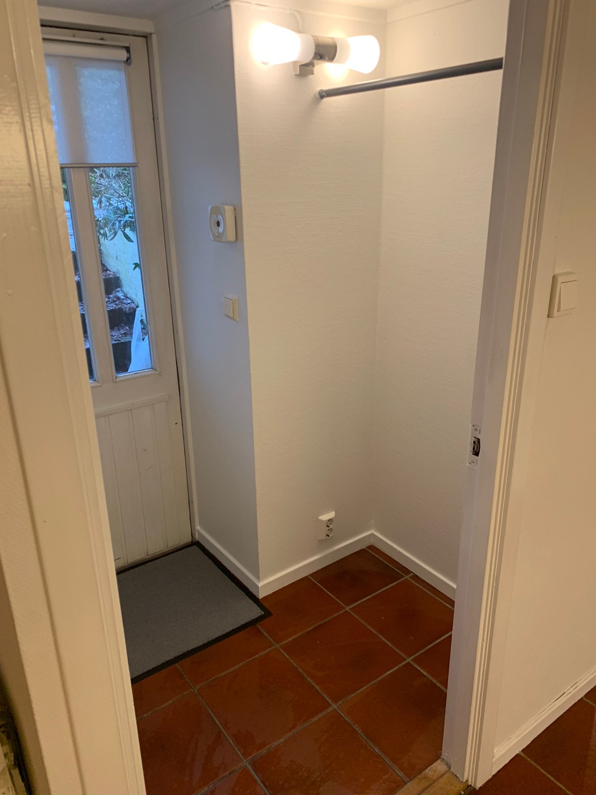 Inngangsparti med plass til sko/yttertøy og skjerming foran dørvindu som slipper lys inn, men helt hindrer innsyn fra utsiden. Galleribilde