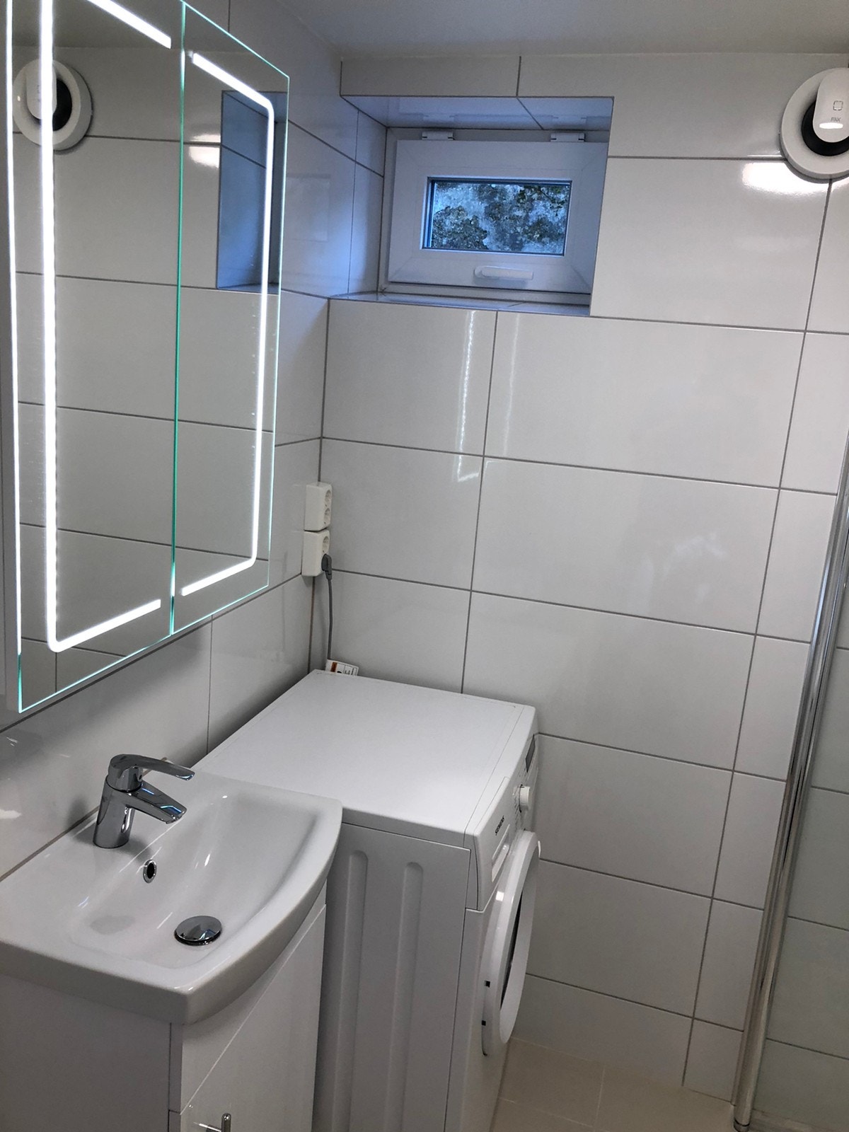 Nyoppusset (2021), lekkert bad med dusj, servant, speilskap med lys og stikkontakt, toalett og vaskemaskin med tørketrommel (annen enn på bildet). Galleribilde