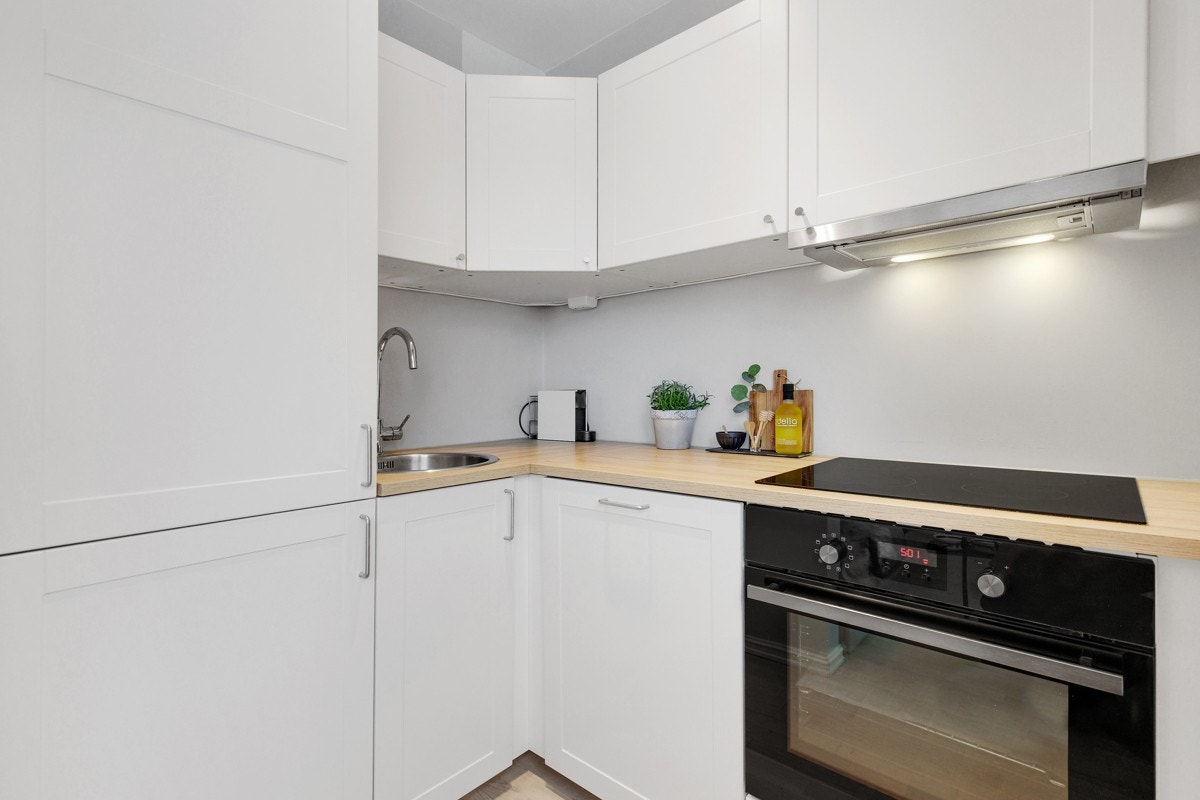 Kjøkkenet har fint med skap- og benkeplass, og alle hvitevarer er integrerte Galleribilde