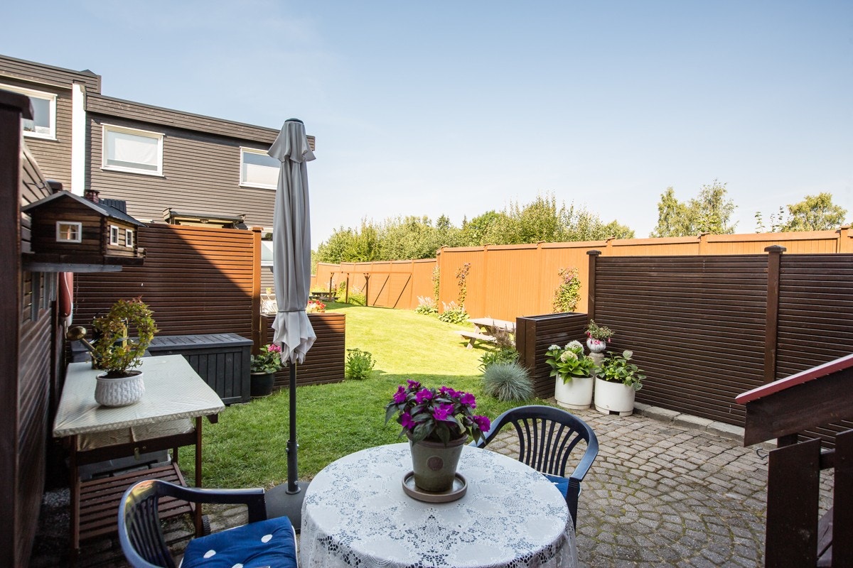 Markterrasse med beplantning, plen og god plass til hagemøbler. Galleribilde