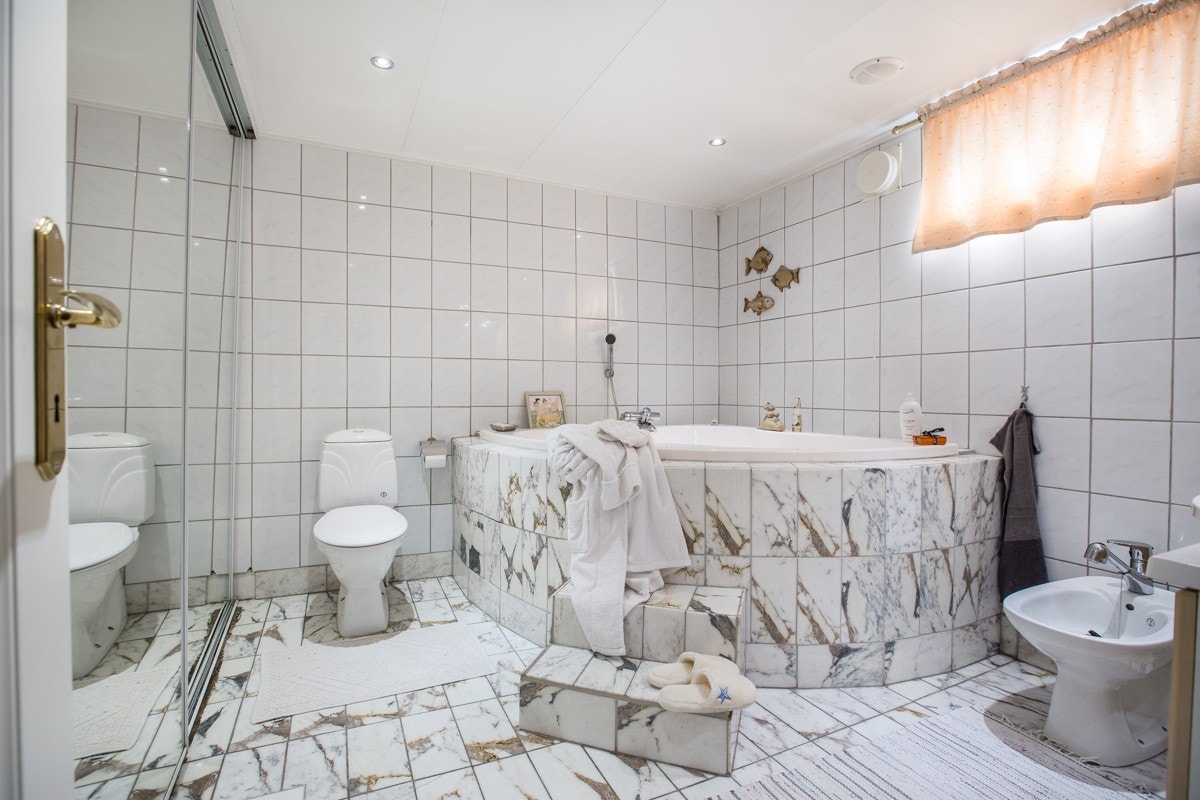 Innfliset (marmorfliser) hjørnebadekar på bad. Galleribilde