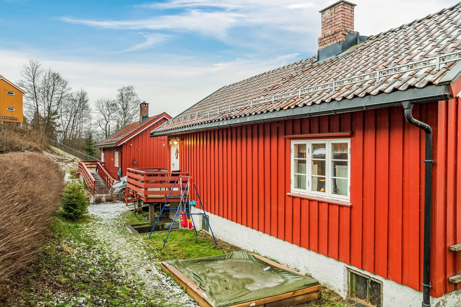 Sjarmerende liten plen rundt boligen med blant annet plass til sandkasse Galleribilde