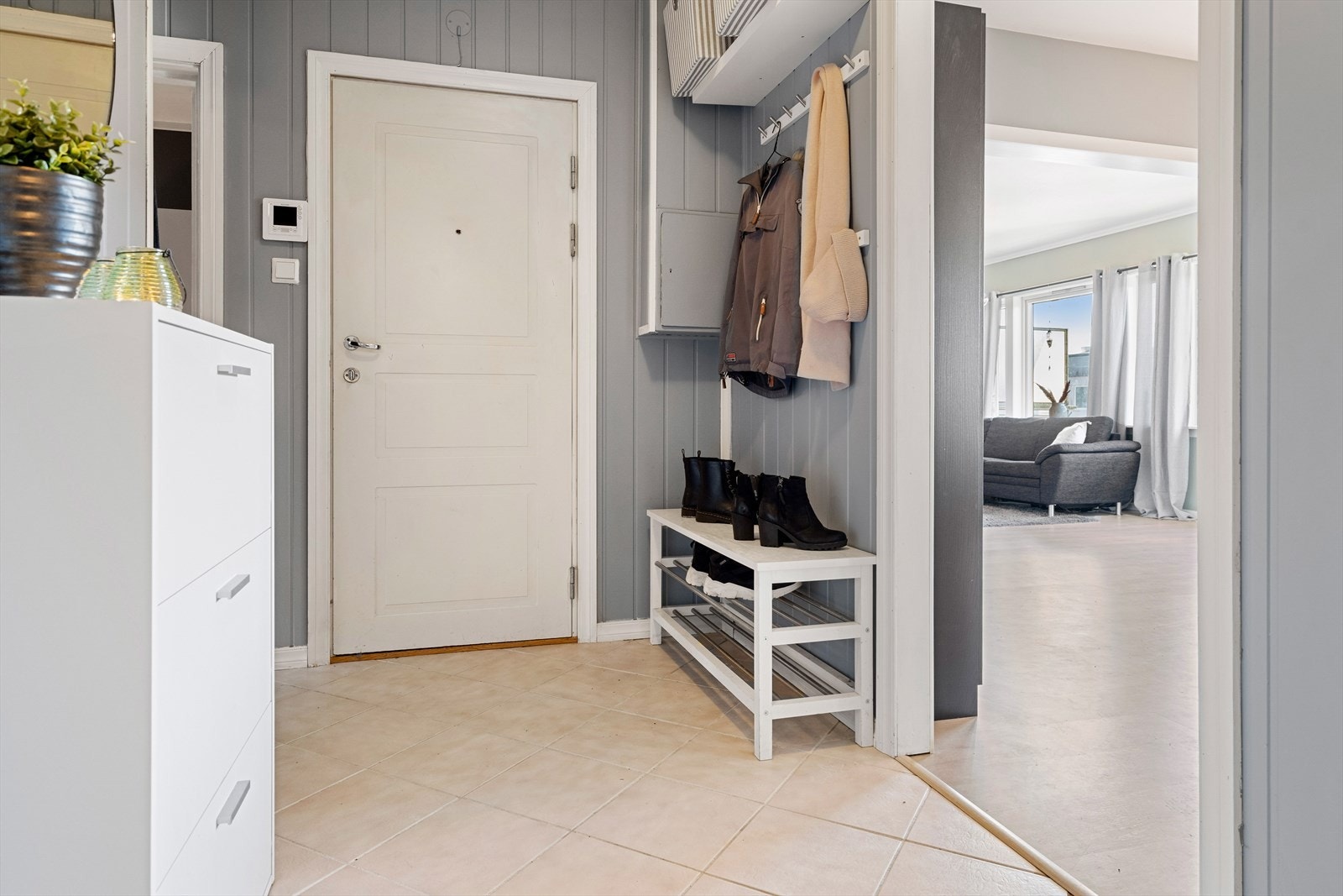 Leiligheten har en stor og romslig entre med fliser på gulv. Galleribilde