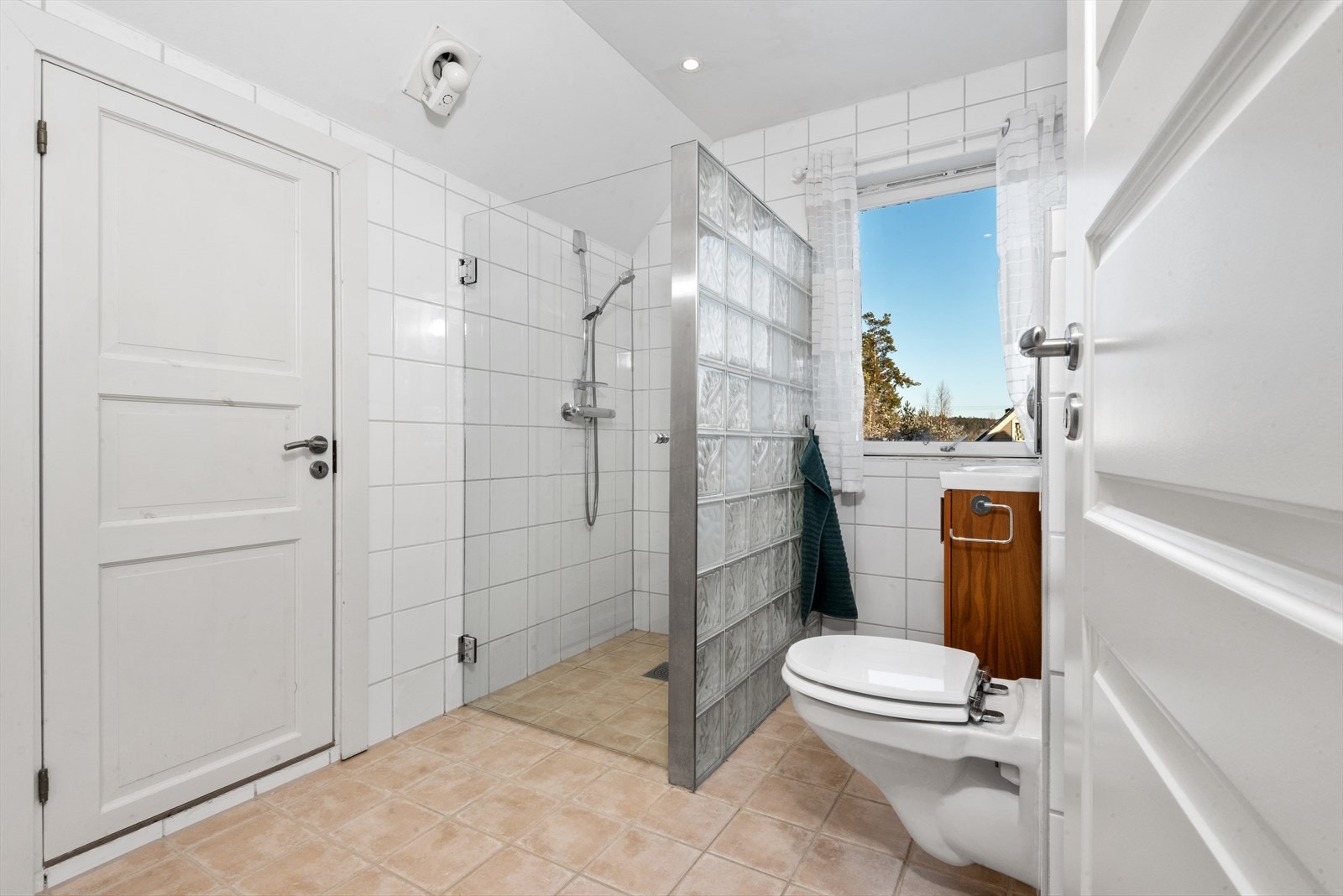 Baderommet er praktisk plassert i 2. etasje ved soverommene. Badet fremstår delikat med hvite fliser på vegger og lyse fliser på gulv samt varme i gulv. Galleribilde