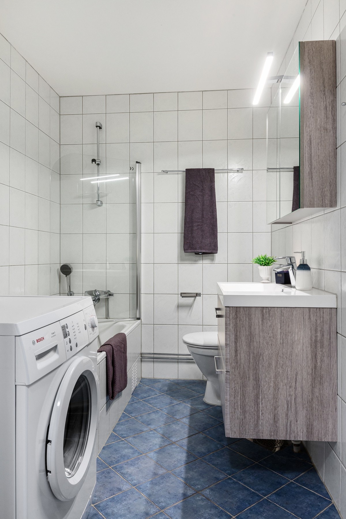 Her får du et innmurt badekar og oppbevaringsplass i servantinnredningen. Galleribilde