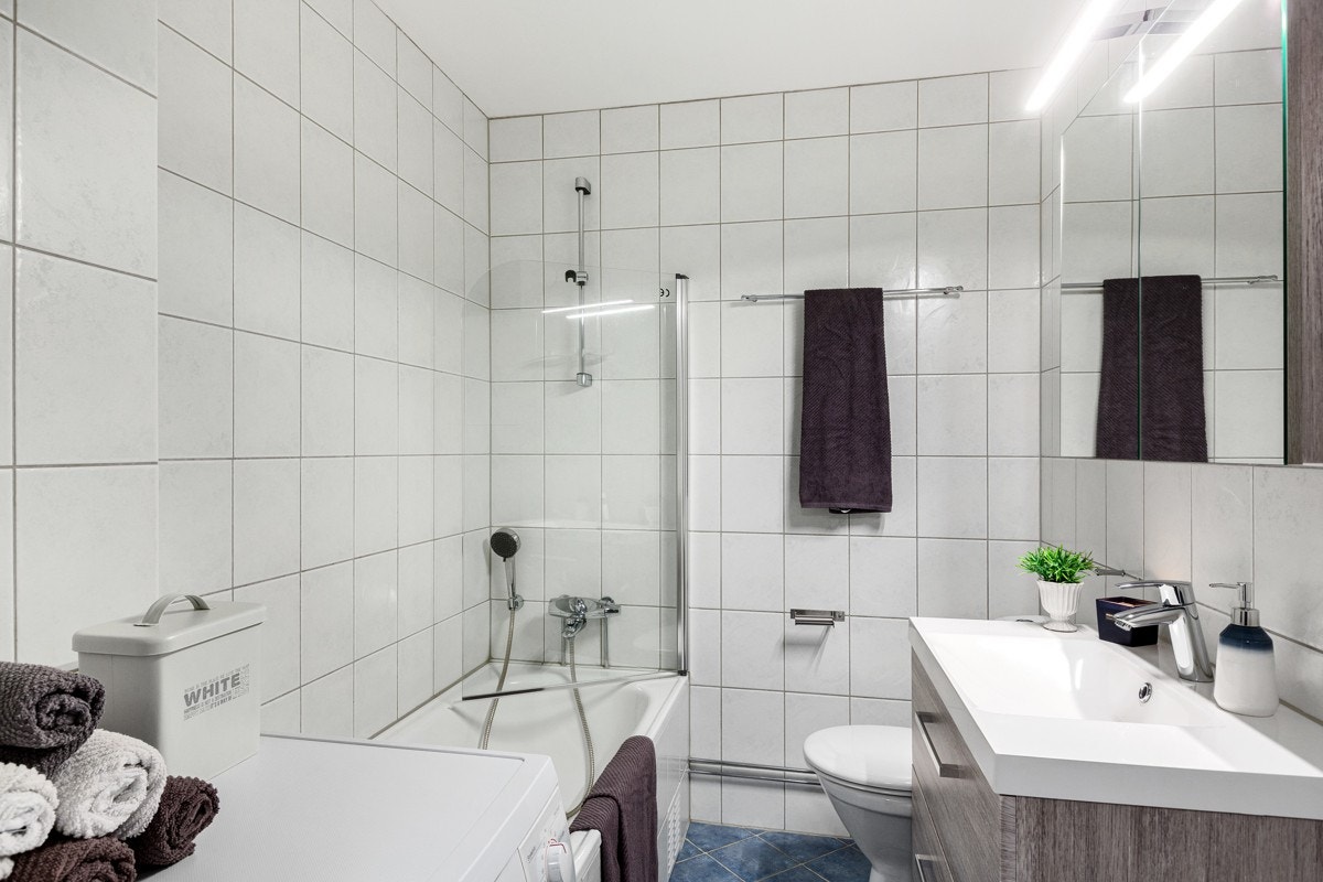 Romslig, flislagt bad med gulvarme og opplegg for vaskemaskin. Galleribilde