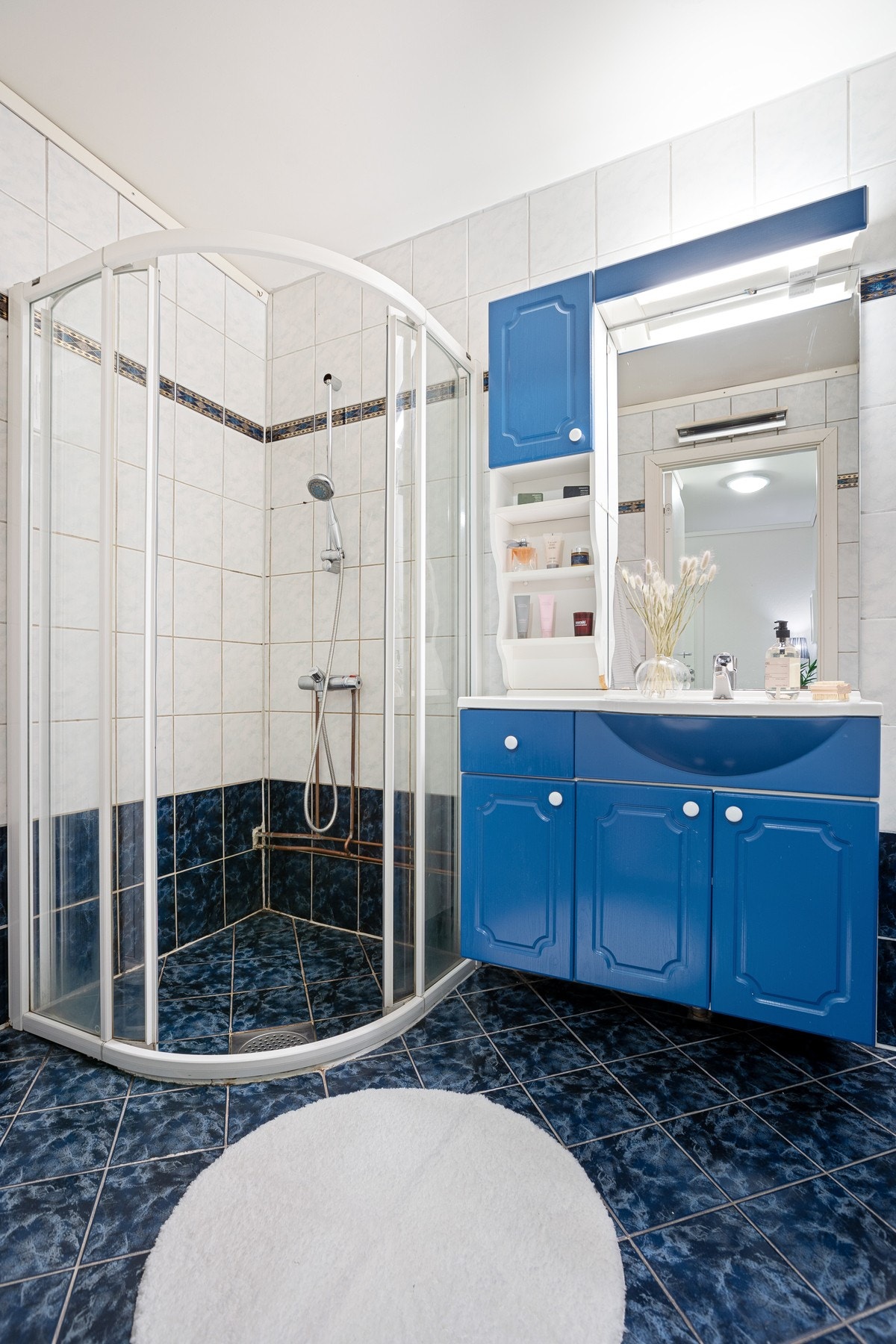 Flislagt bad med dushjørne, wc og innredning mer servant og speil Galleribilde