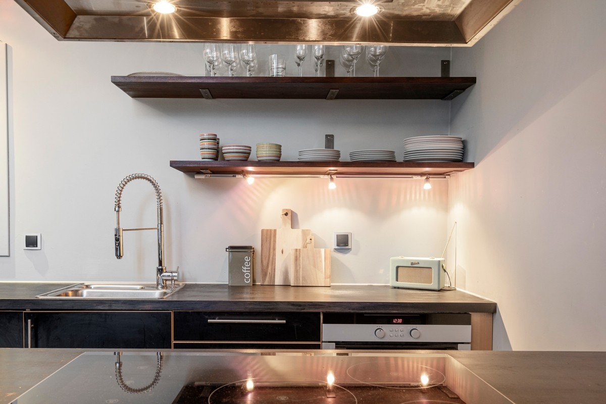 Kjøkkeninnredning fra byggeår fra Sigdal med glatte sorte fronter på skuffer- og skapfronter. Galleribilde