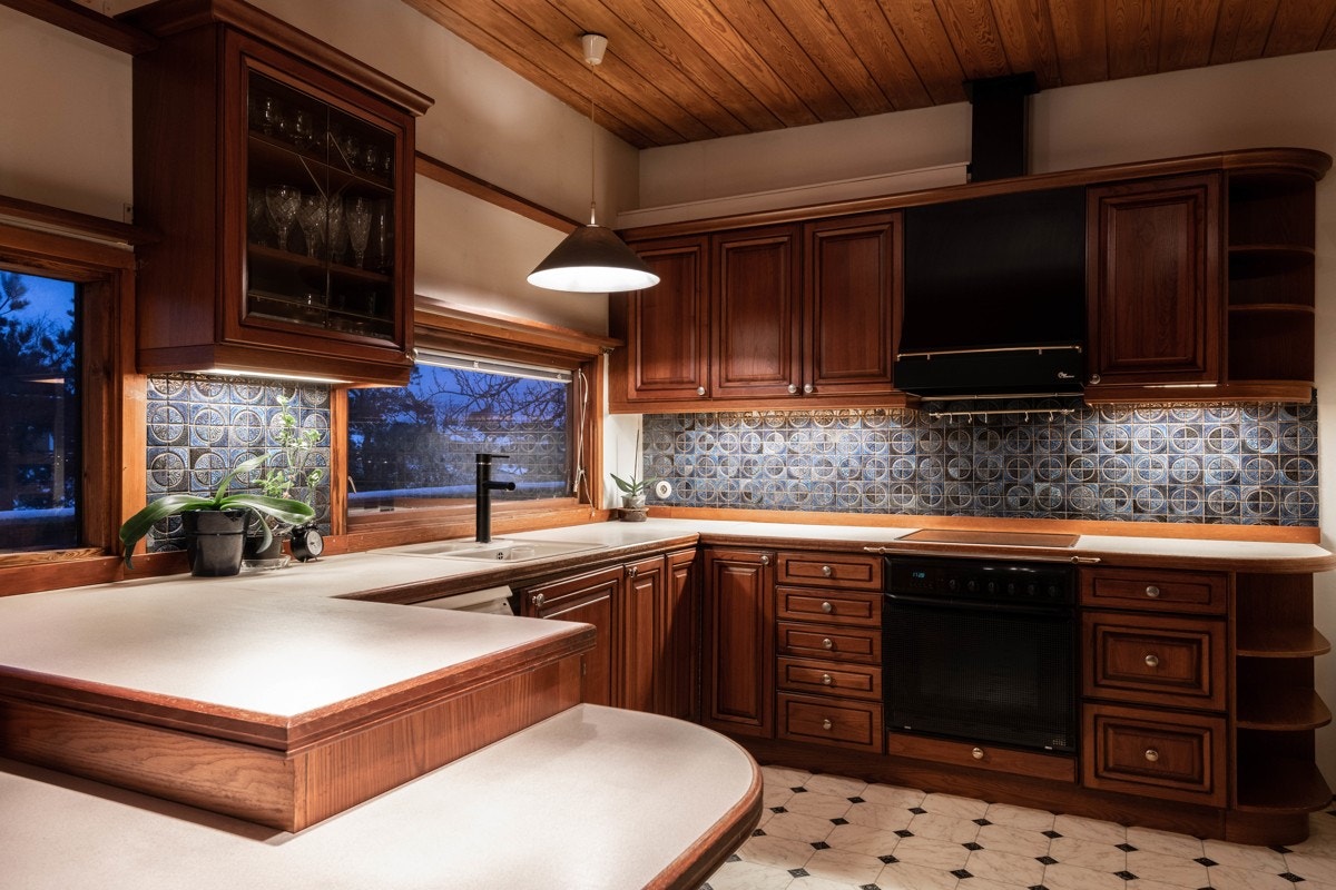 Det er fliser og belysning over benkeplaten og ved oppvaskkummen er det et vindu som både gir lys og utsikt mot hagen. Galleribilde