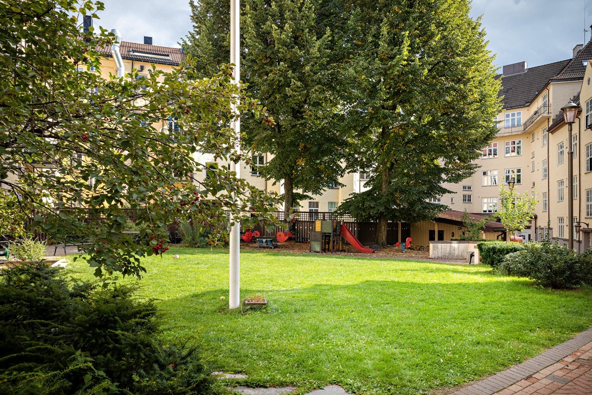 Bakgården pent opparbeidet med lekestativ og sitteplasser Galleribilde